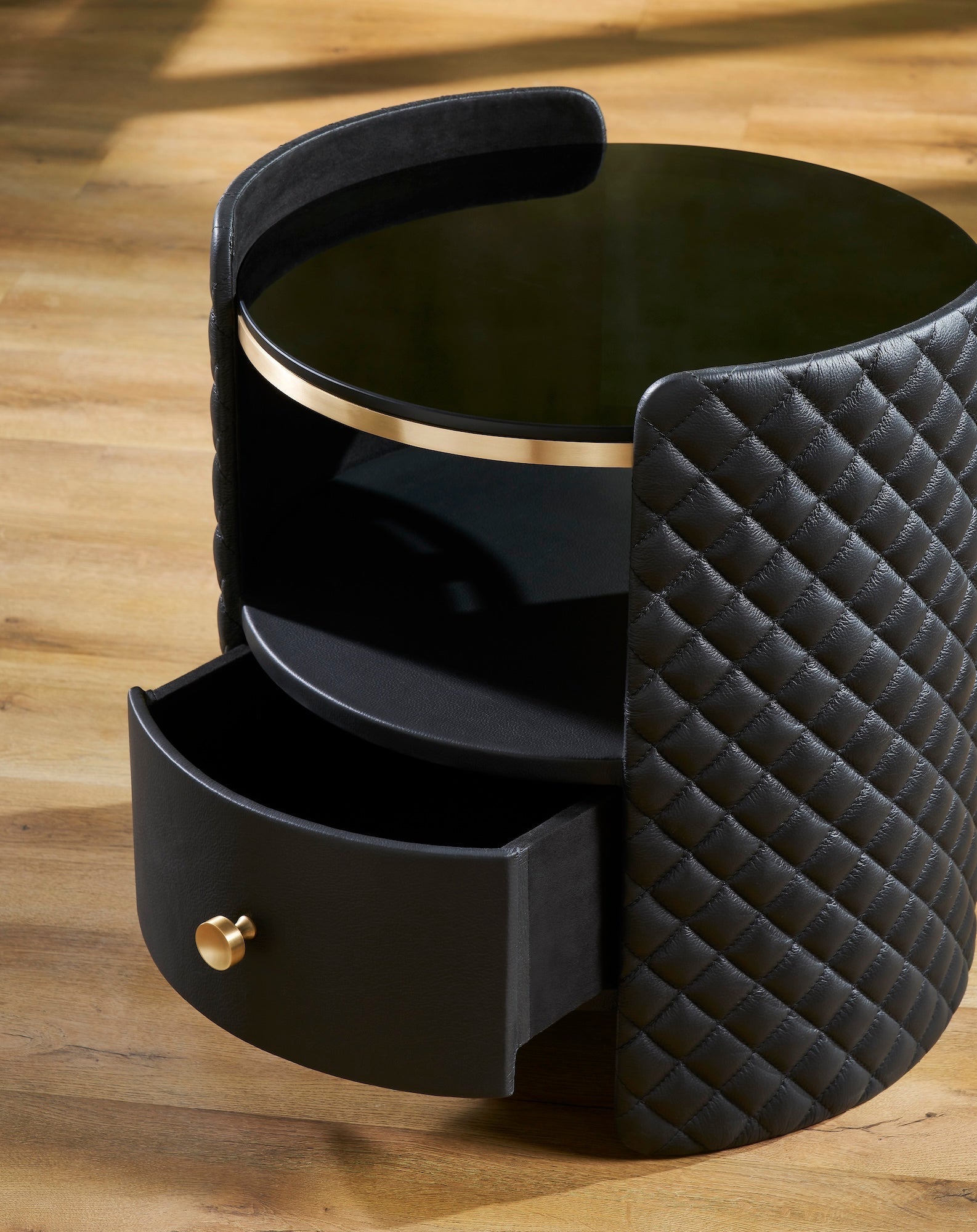 FN-5215-202022_4|Detailed view of black quilted leather nightstand with gold hardware and open drawer, revealing luxury bedroom storage.
