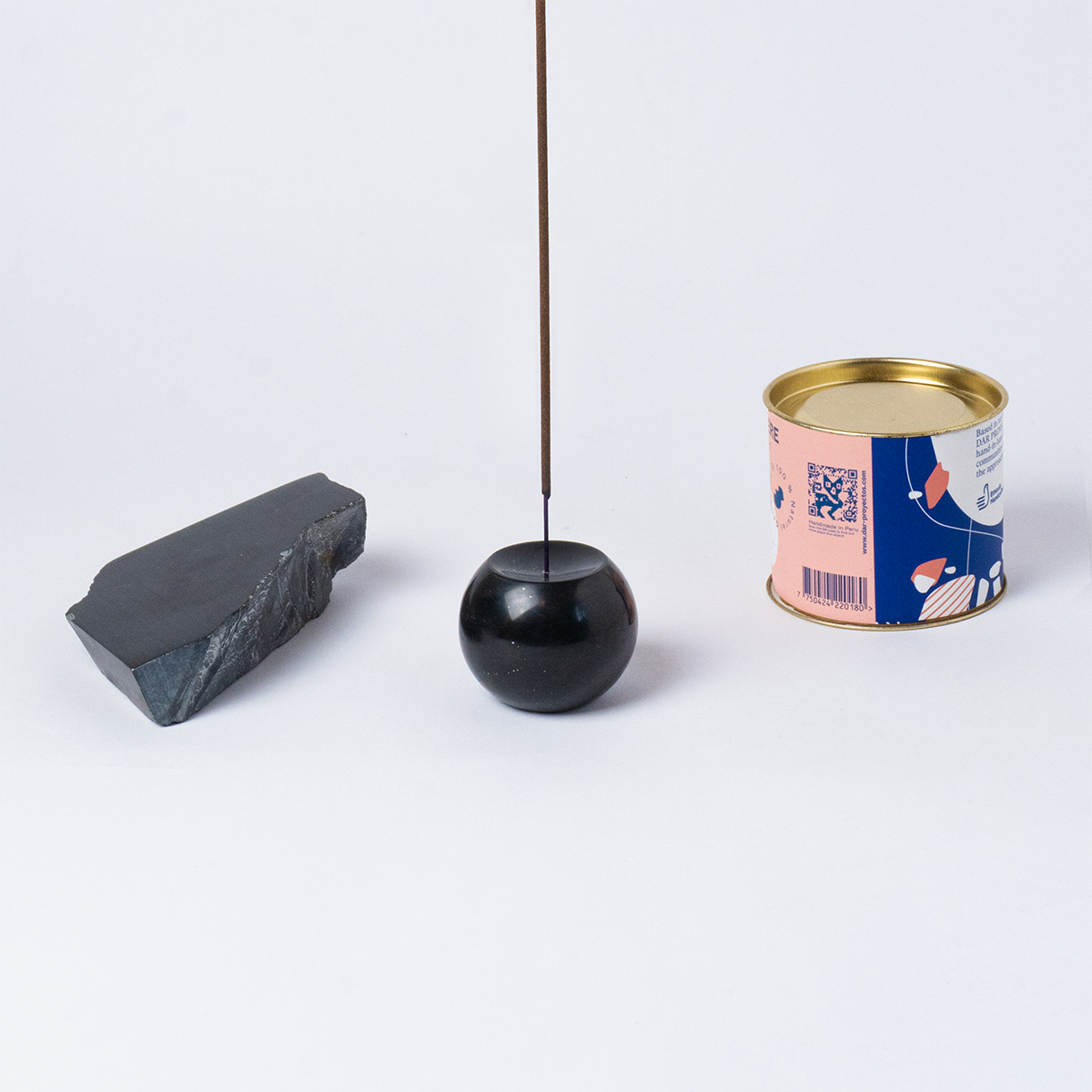 Black onyx gemstone sphere incense holder carved from natural stone on a white background.