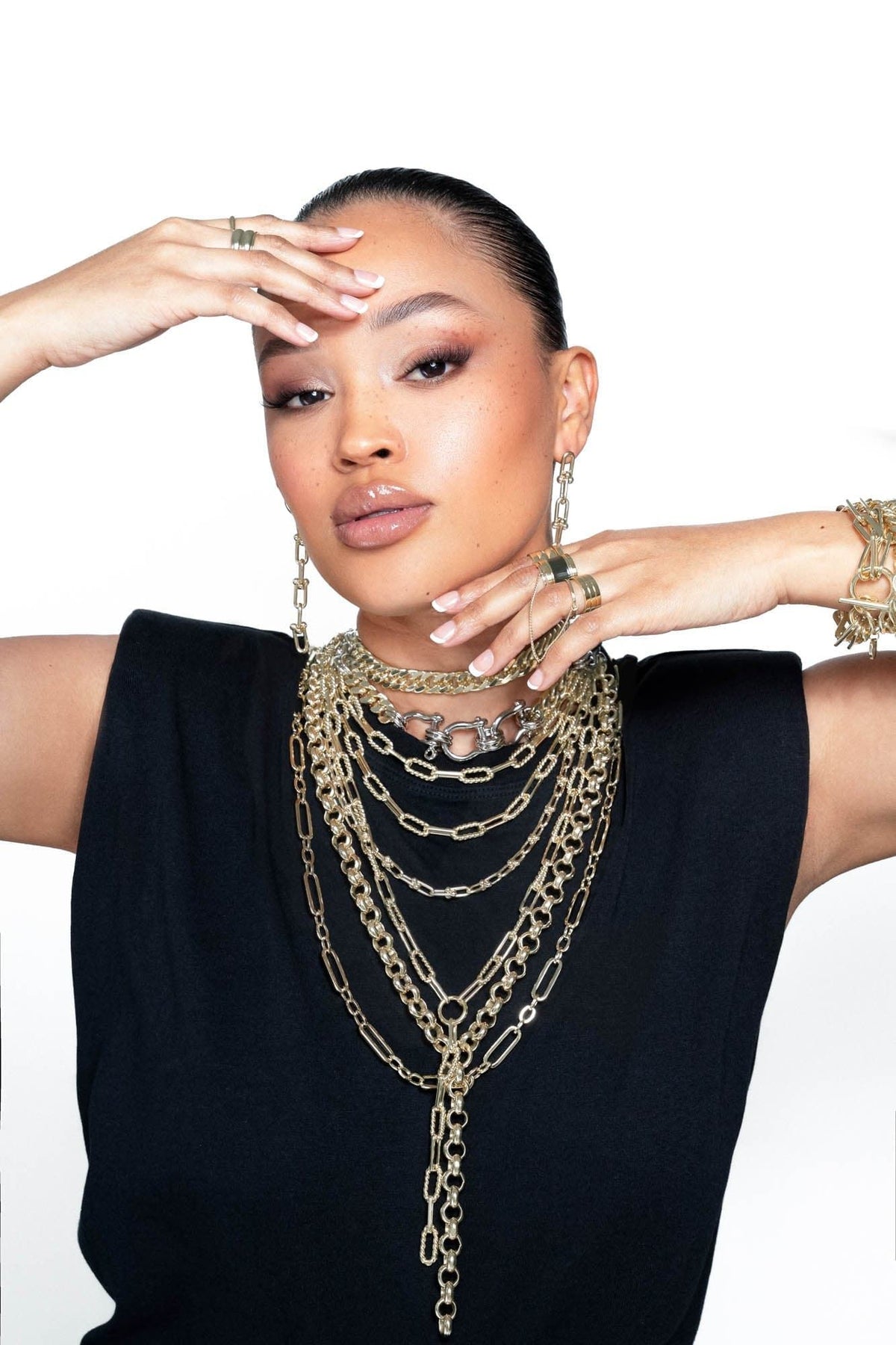 Woman wearing layered gold necklaces showcasing the Enzo Lariat Necklace style