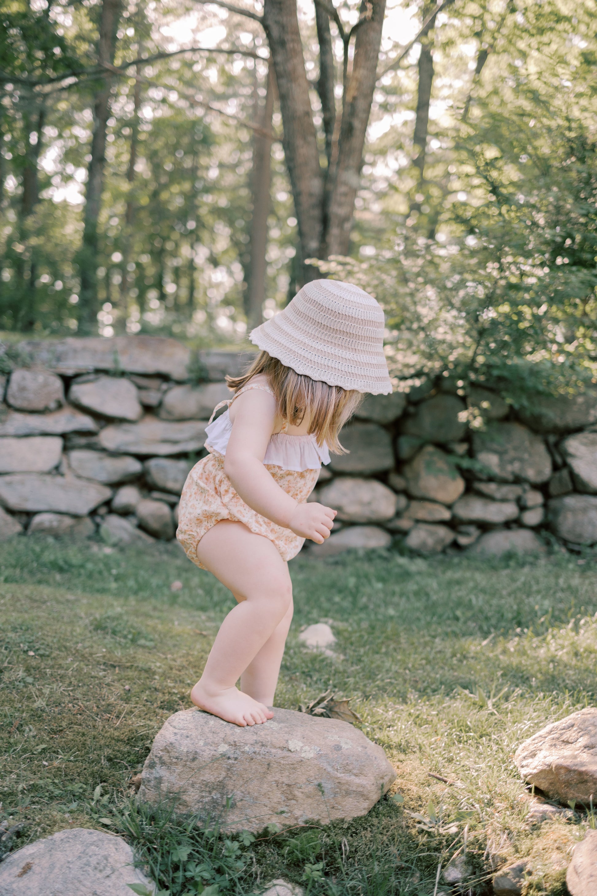Child wearing the Maia Romper and sun hat