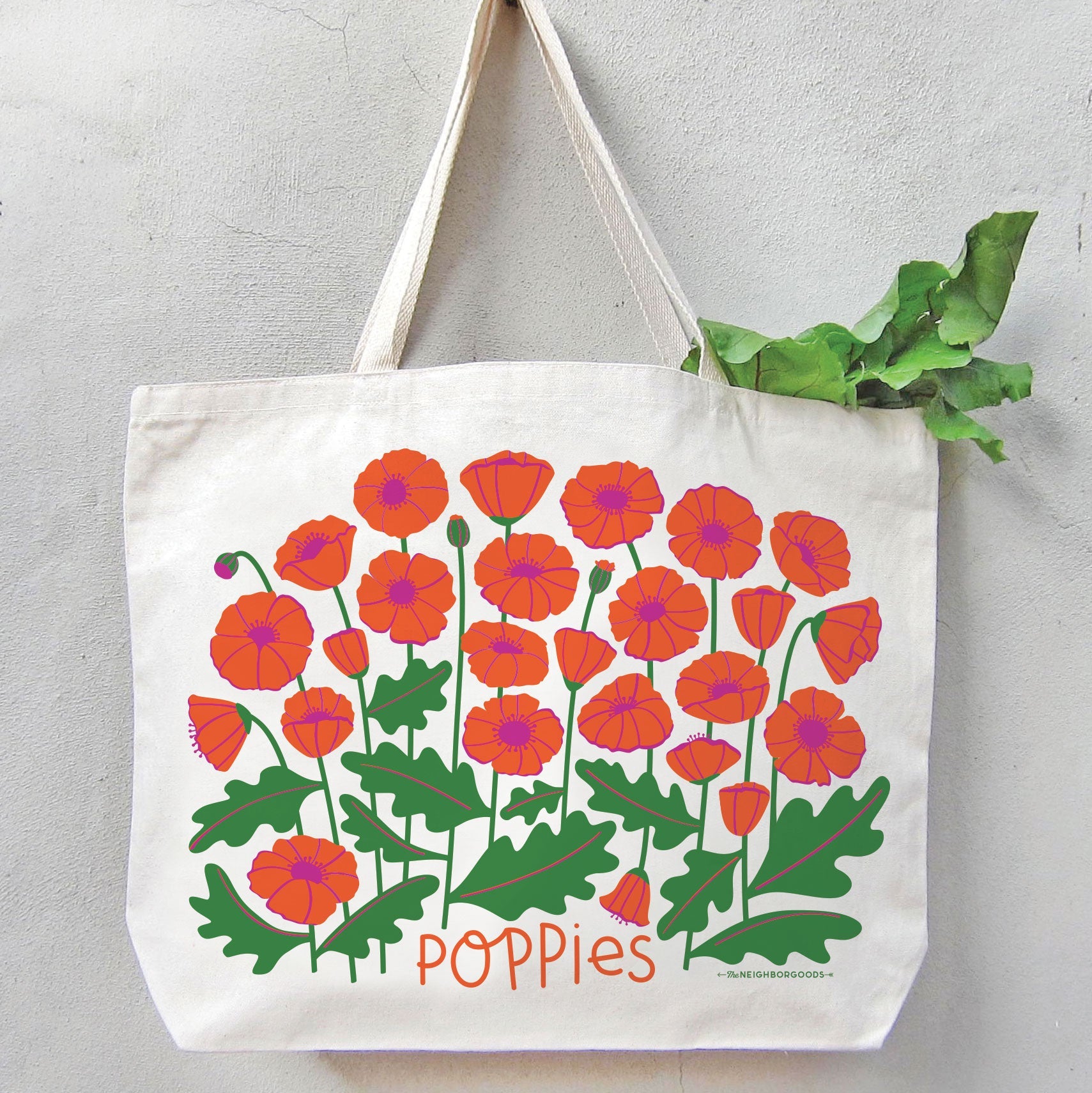 The Poppies tote bag filled with green leafy produce, with the greens peeking out from the top.