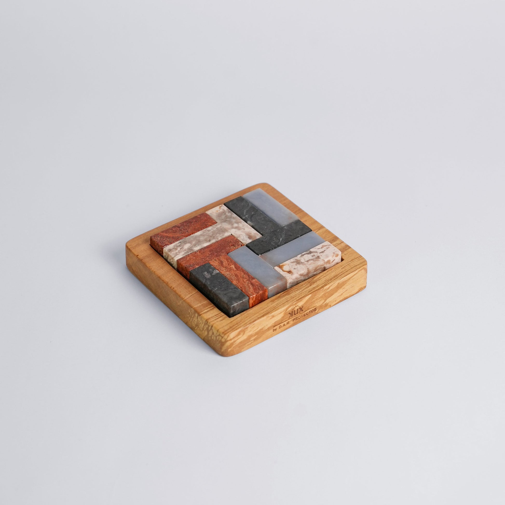 Assembled multi-stone Tetris puzzle emphasizing its geometric precision on a white background.