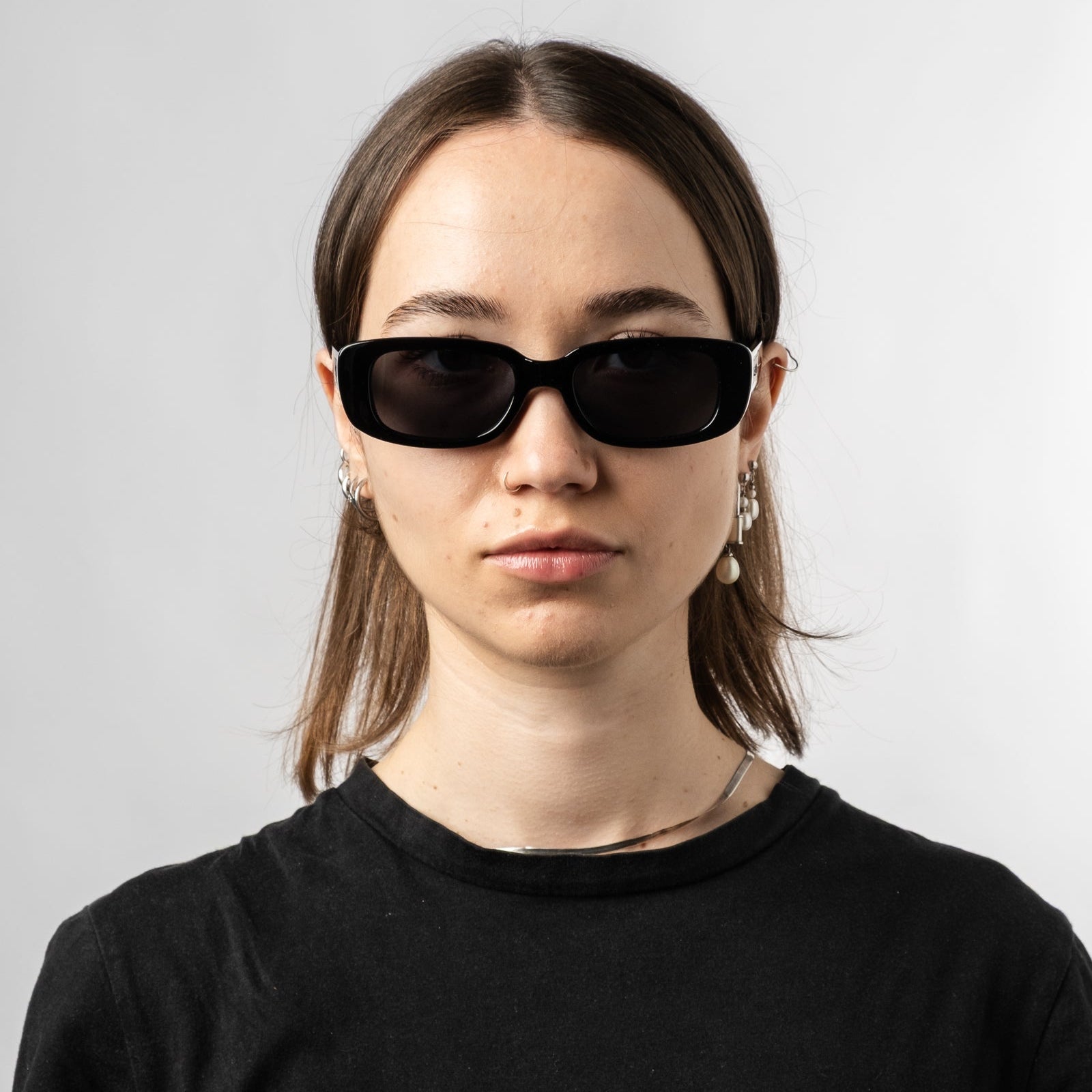 Female wearing Sad Eyewear Bouquet rectangle sunglasses in gloss black with black tinted lenses