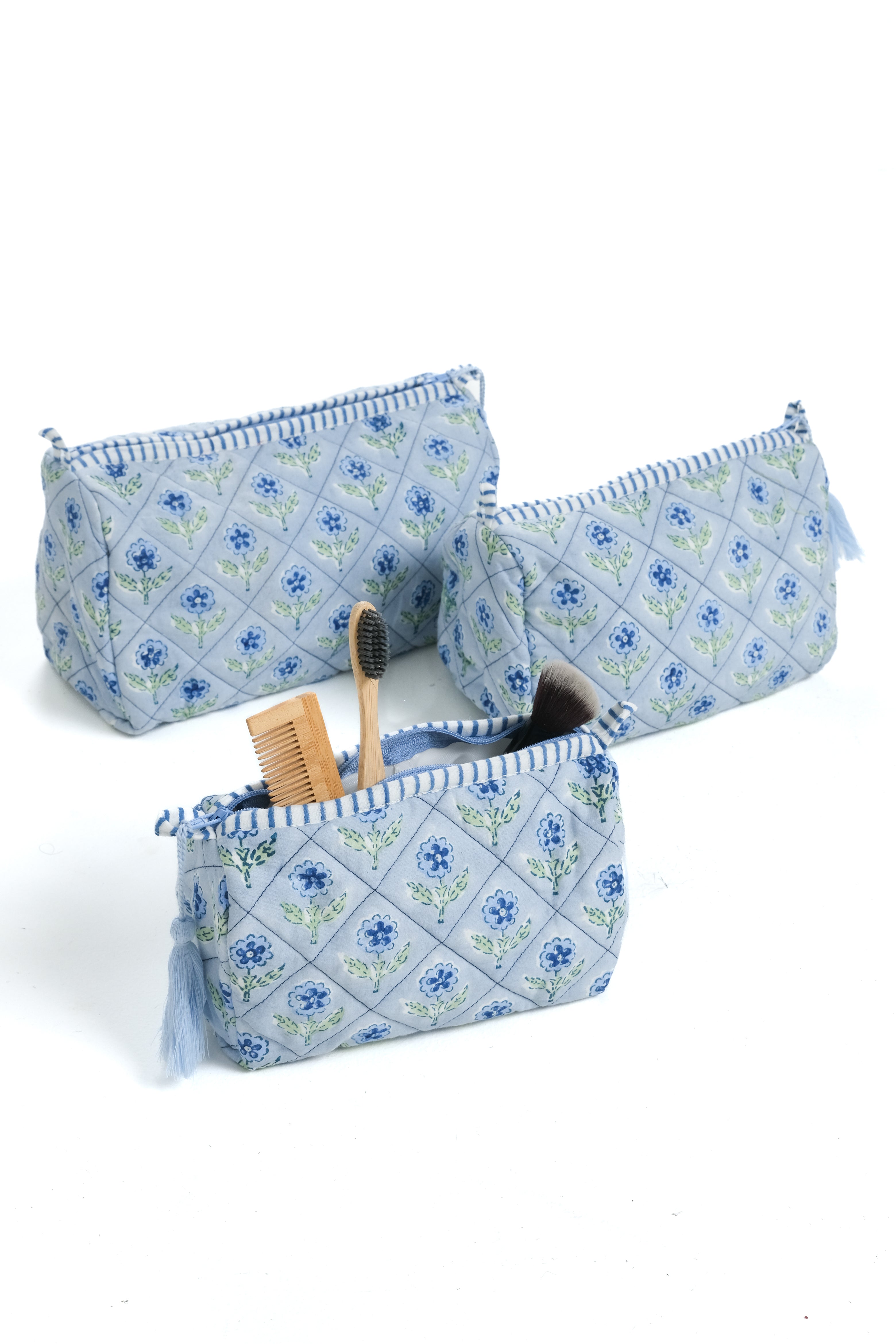 Three blue blockprint bags with floral design, one open