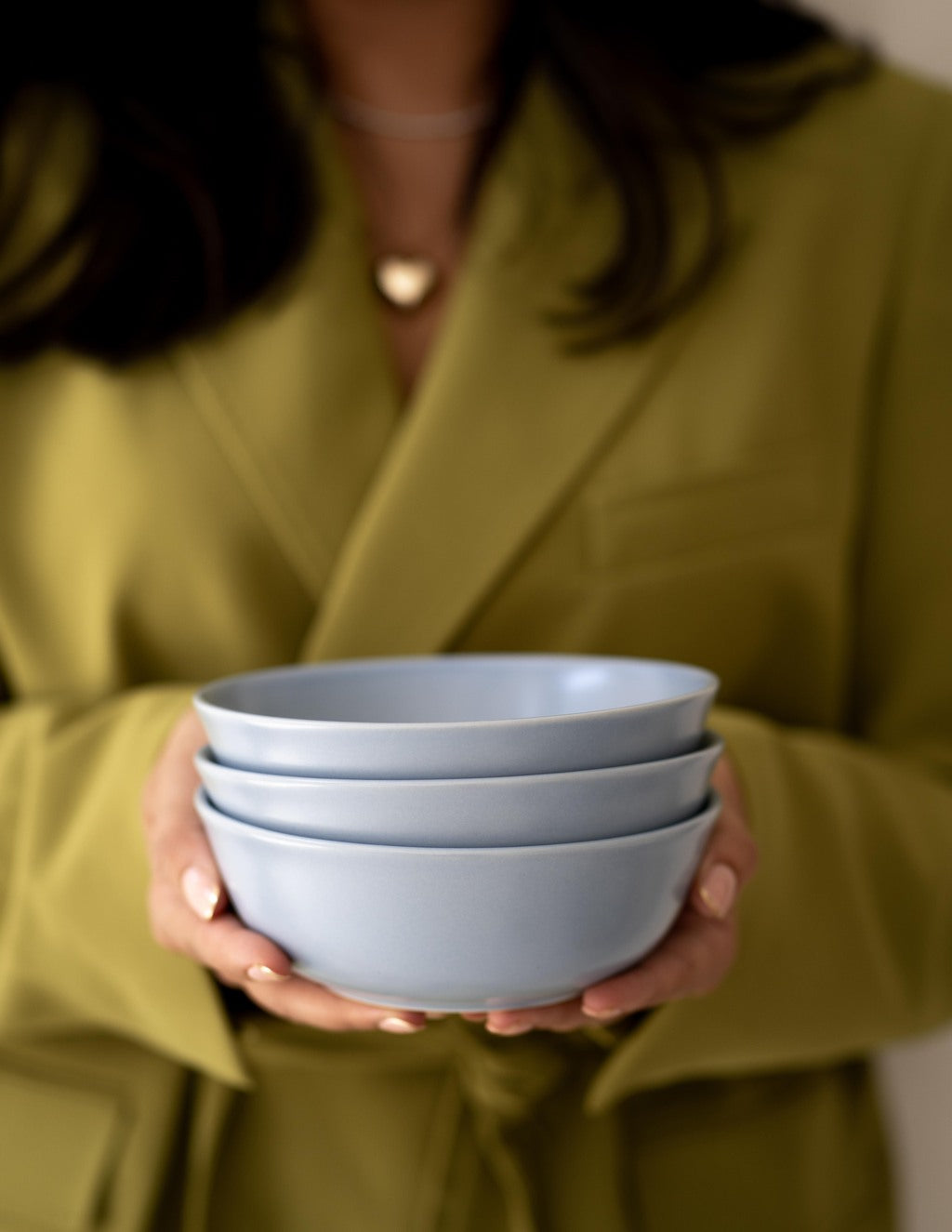 Blue non-toxic ceramic bowls from Hamkke Home held in hands, showcasing heirloom-quality stoneware.