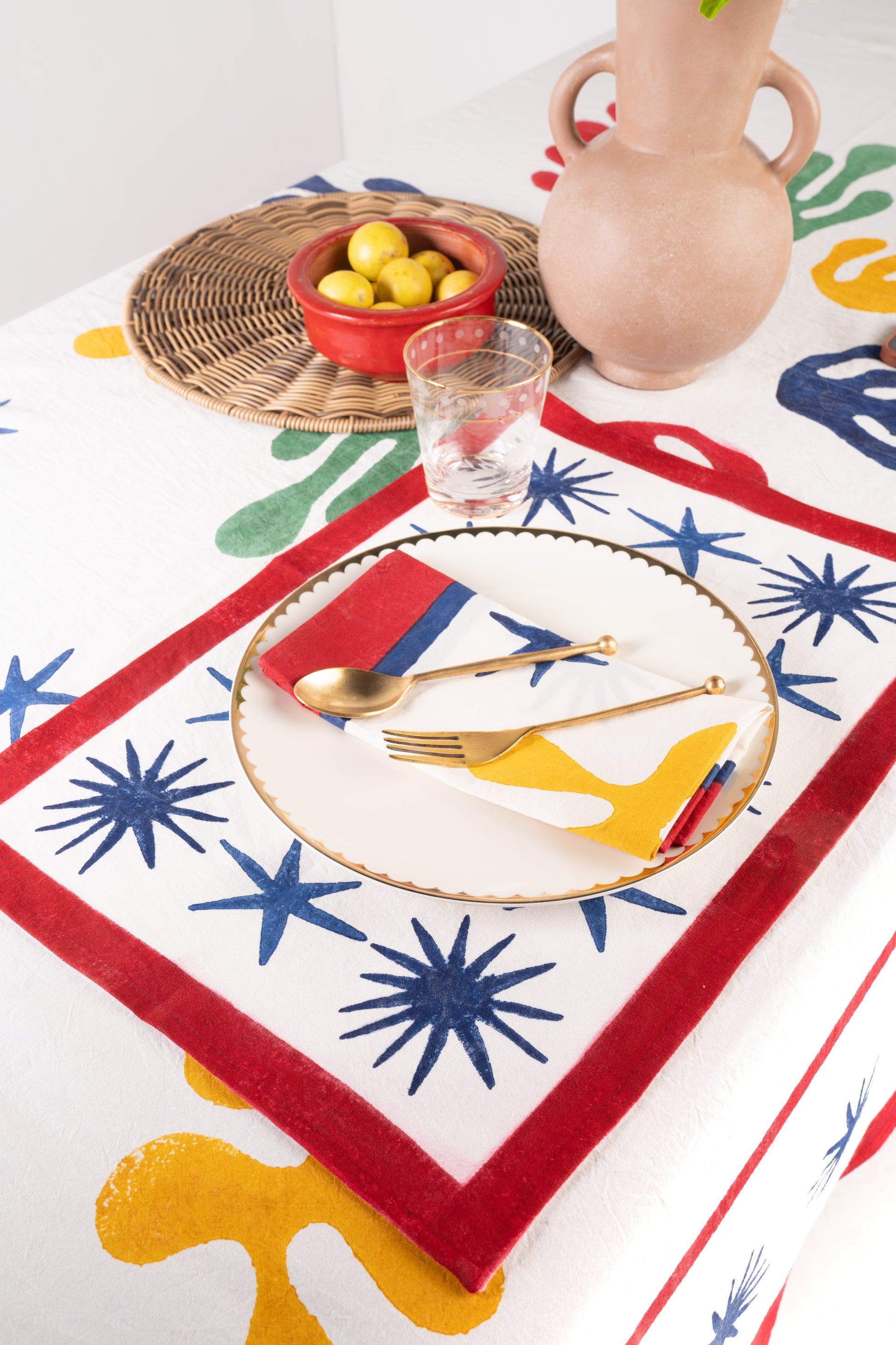 Inner Child Celestial Matisse Blockprint placemat with red borders and gold utensils