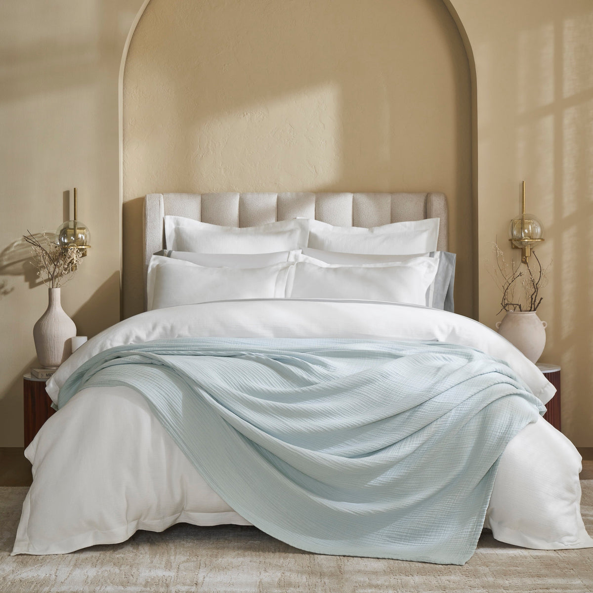 BL-863-11096_1|Luxurious light blue textured muslin blanket draped gracefully over a crisp white duvet in a modern, elegant bedroom setting.