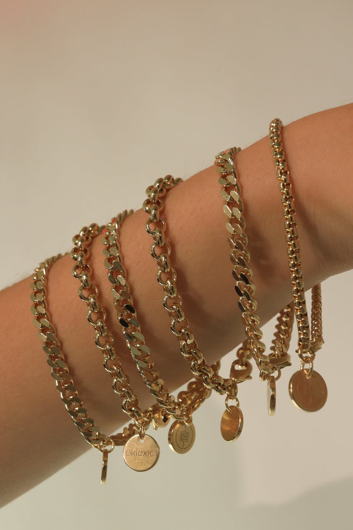 Gold chain bracelets with circular pendants from Micro Royal Rolo Chain Bracelet collection