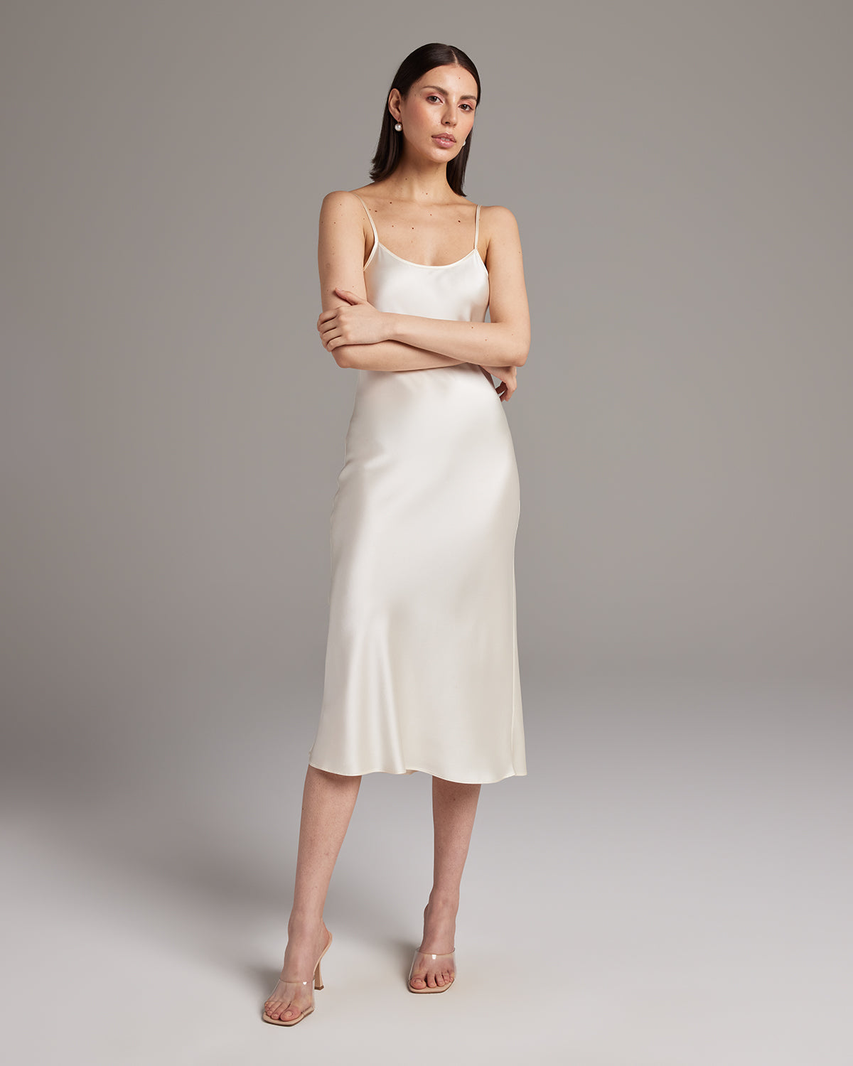 Model wearing a cream Midi Slip Dress with spaghetti straps