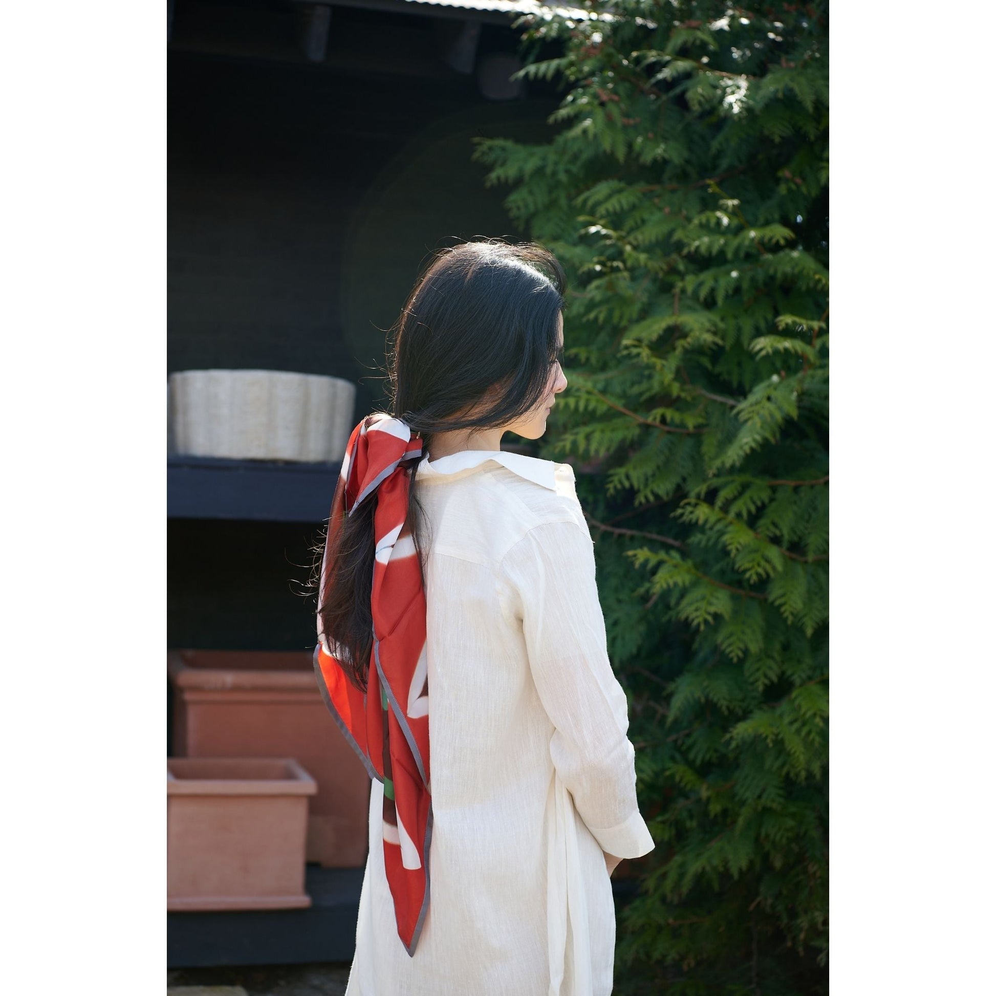 Fawn Square Silk Artisanal Scarf In Multicolor Hand Crafted Shibori Print tied in hair, showcasing vibrant colors and patterns.