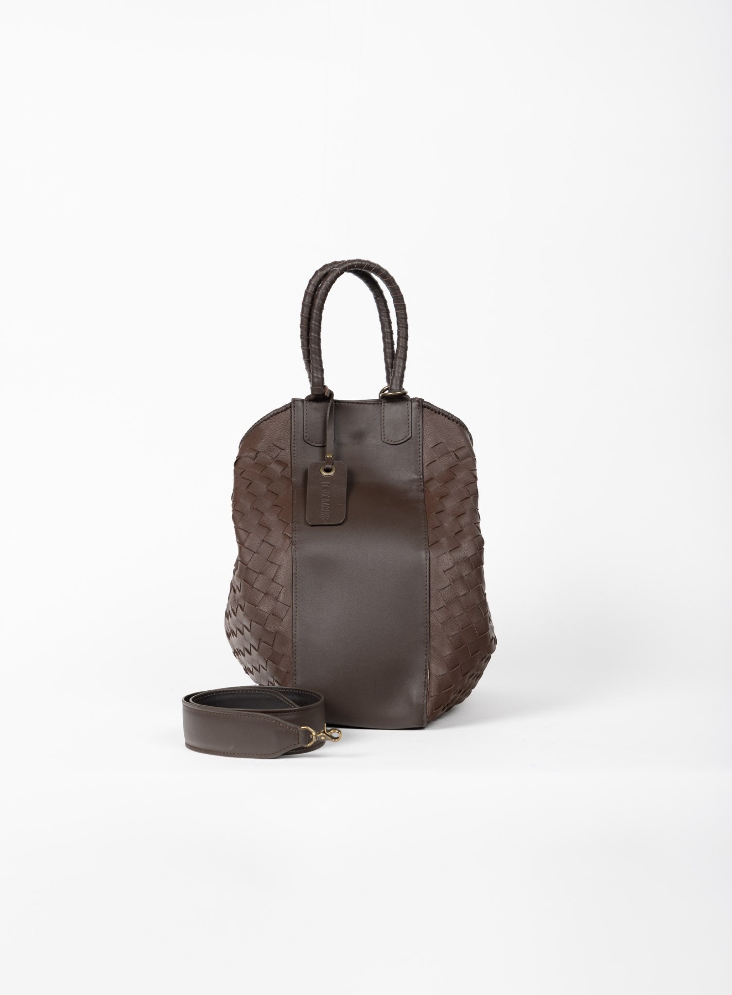 All day tote mahogany spring collection sitting on a box held by model.