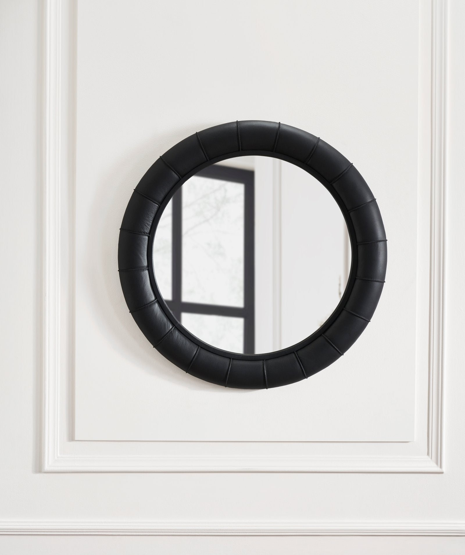 FN-5202-33233_3|Modern black leather-framed round mirror, showcasing a padded, channel-tufted frame, perfect accent for premium leather furniture.