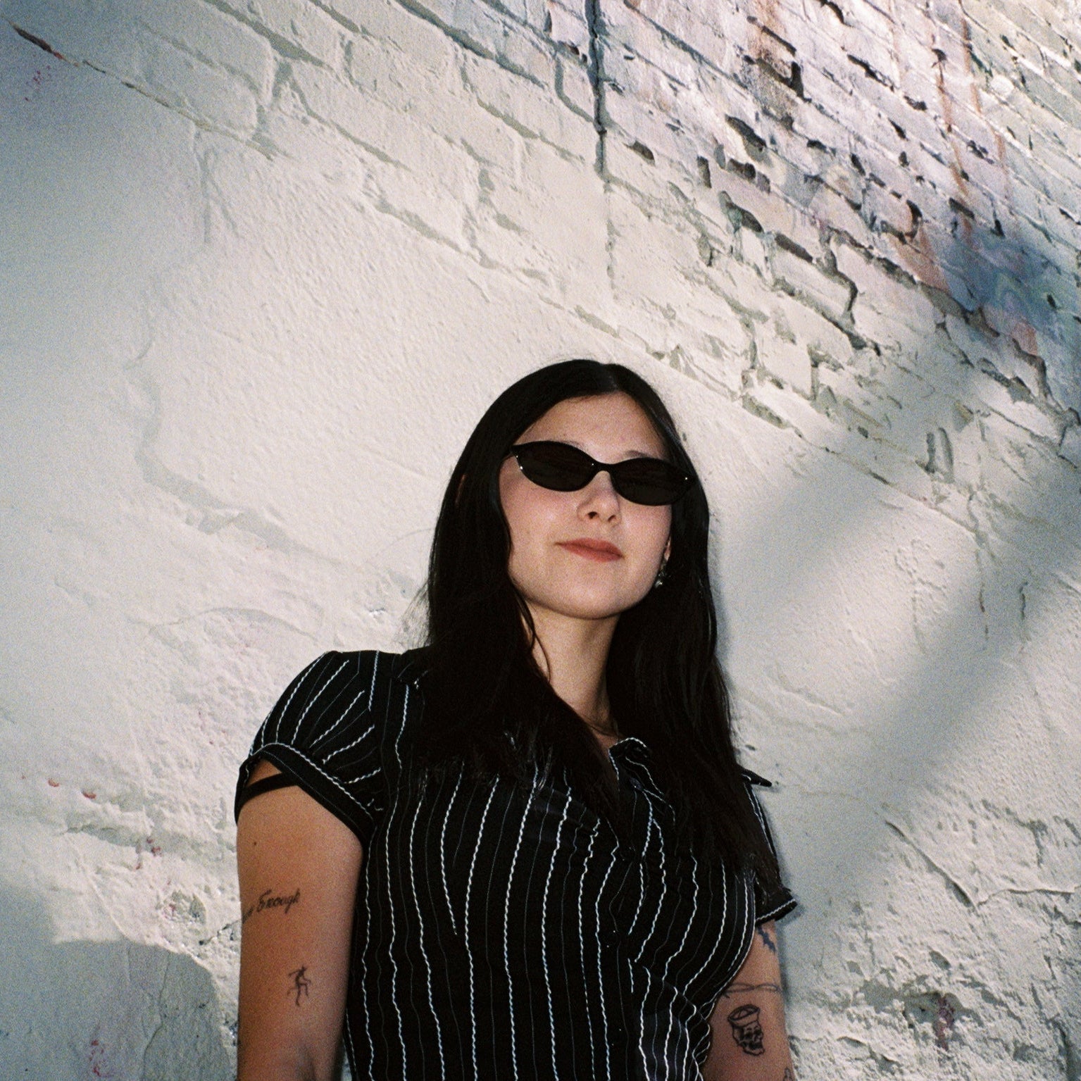 Macey Lemus wearing SAD Eyewear Celeste oval sunglasses in black with polarized grey UV protection lenses