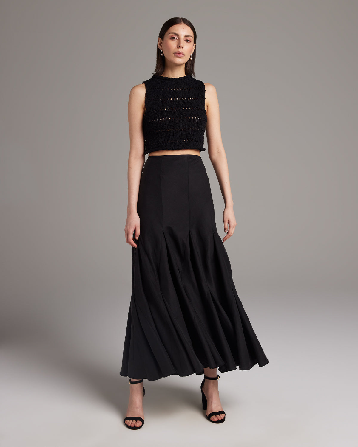 Model wearing a black Flammé Knit Crop Top with a black skirt