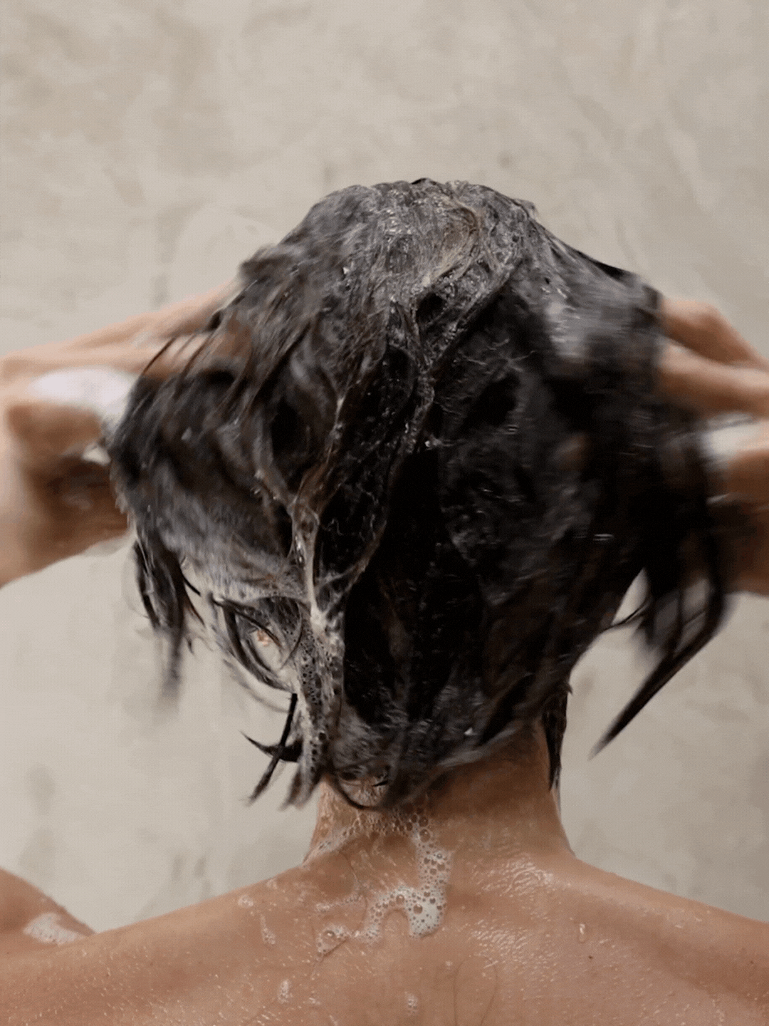 woman lathering and shampooing hair with aloe vera shampoo