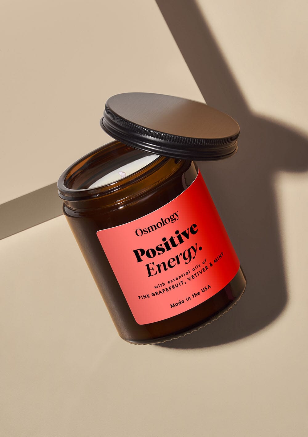 Osmology Positive Energy jar candle with open lid on white background
