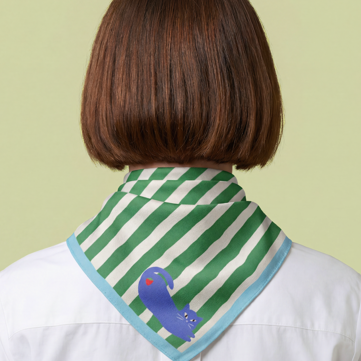 woman wearing a green and white striped scarf with a blue cat and strawberry, with cyan blue border, on a light green background