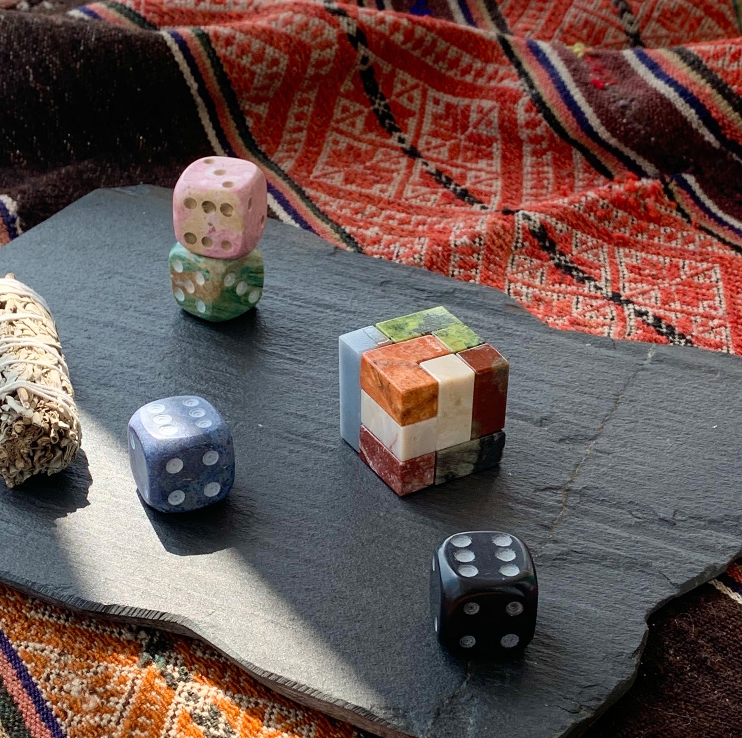 Natural gemstone Soma puzzle adding a touch of tactile quiet luxury to a modern desk setup alongside curated books.