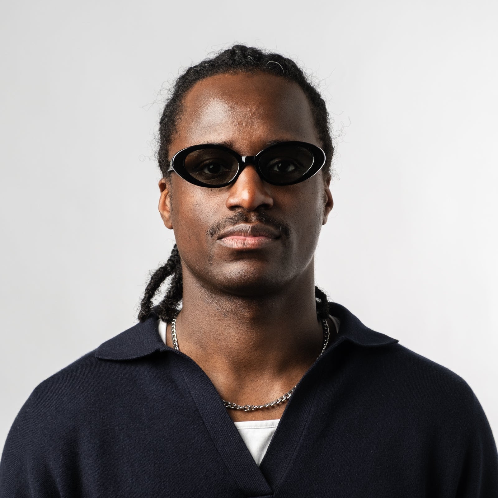 Male wearing Sad Eyewear Bloom oval sunglasses in black with tinted olive lenses