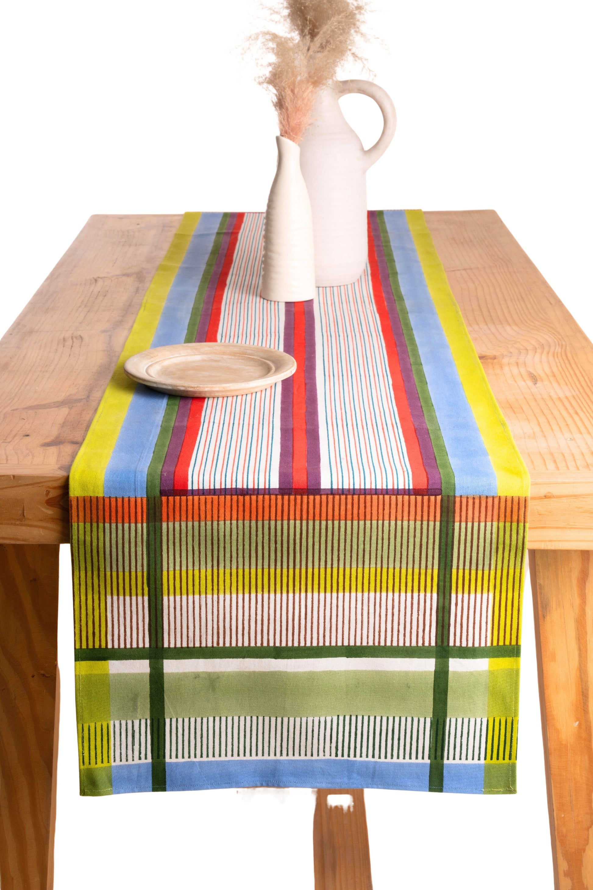 Modernist striped tablerunner on wooden table with white vase and pink flowers