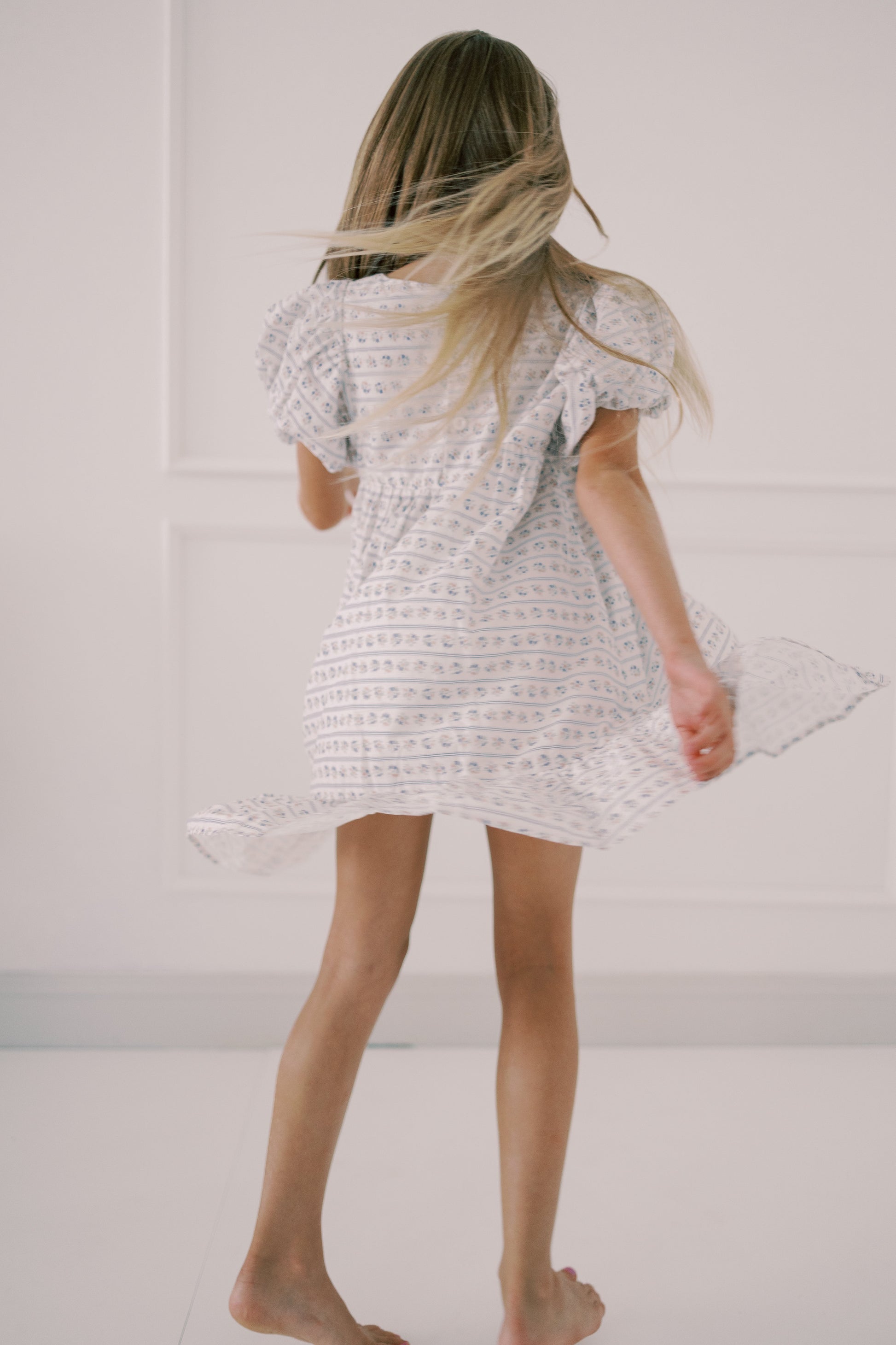 Person wearing a white textured dress against a plain background