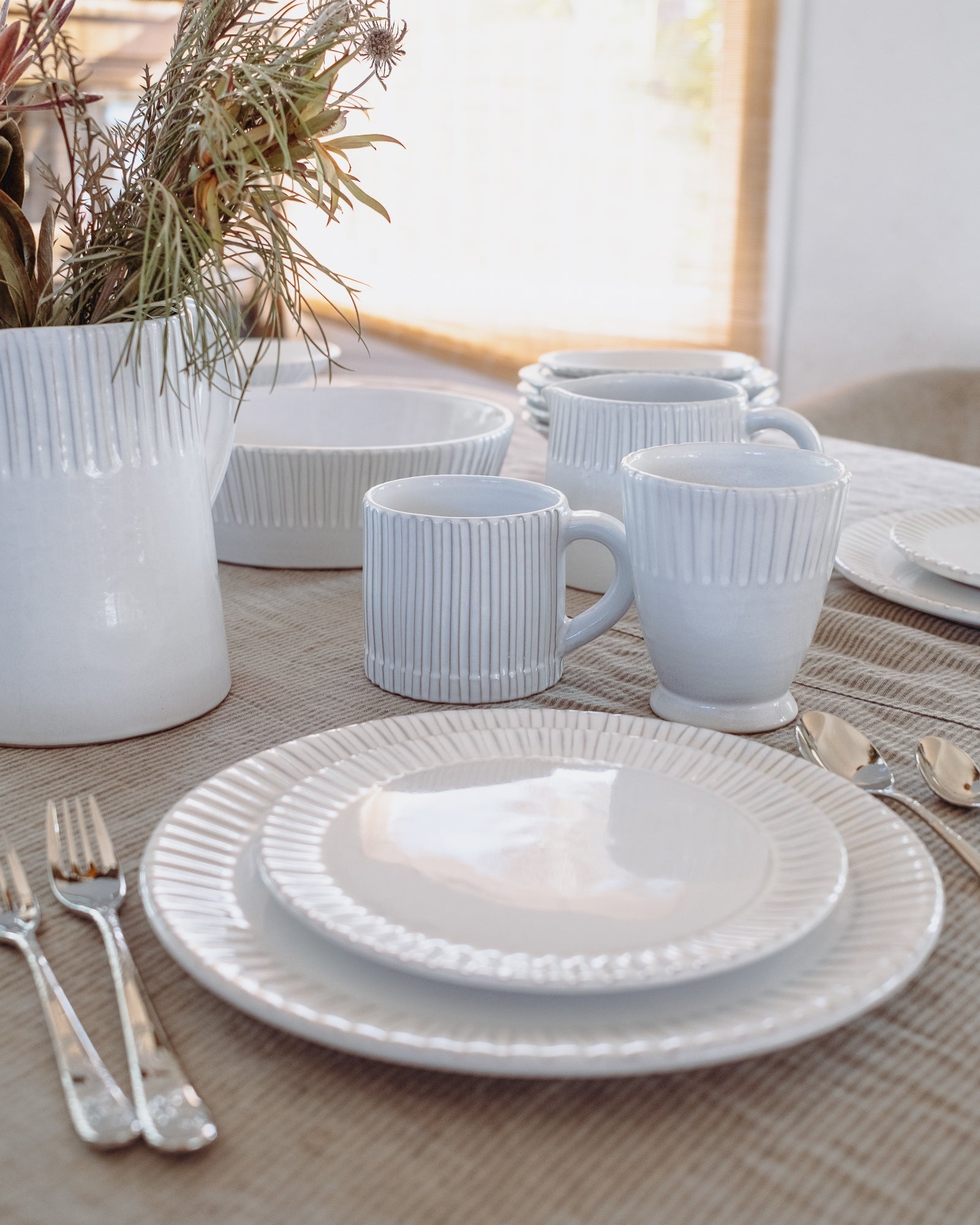 White ceramic tableware set on a table with a neutral background