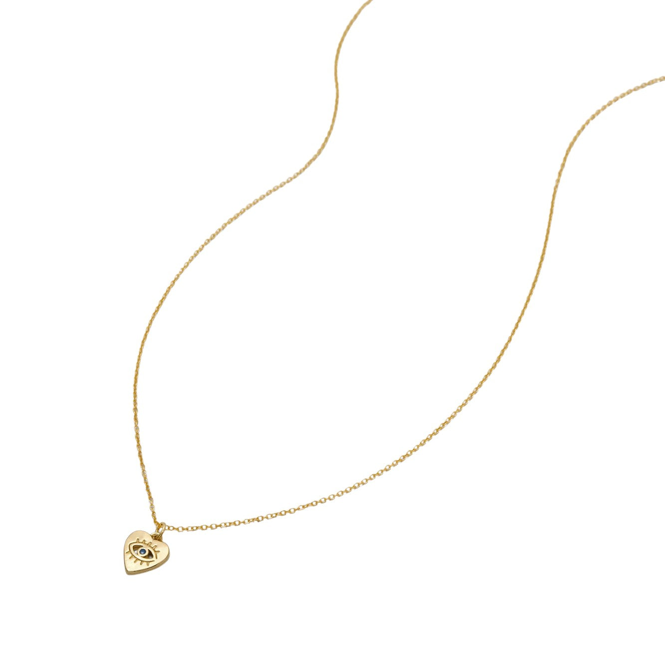 Dainty gold necklace with a heart-shaped pendant with evil eye engraving on a white background, made by Katie Dean Jewelry.