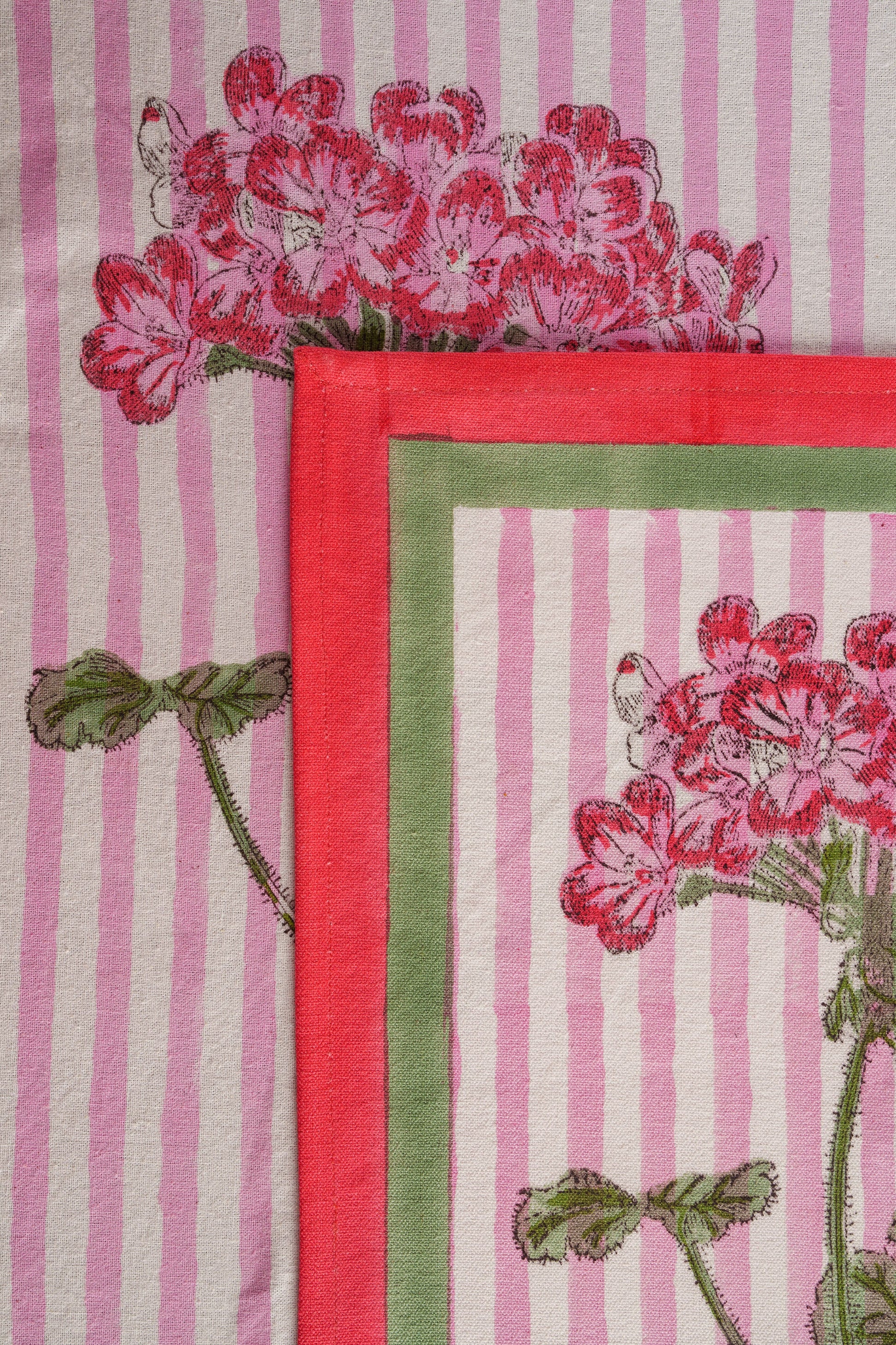 Close-up of pink hydrangea blockprint placemat with red/green border details