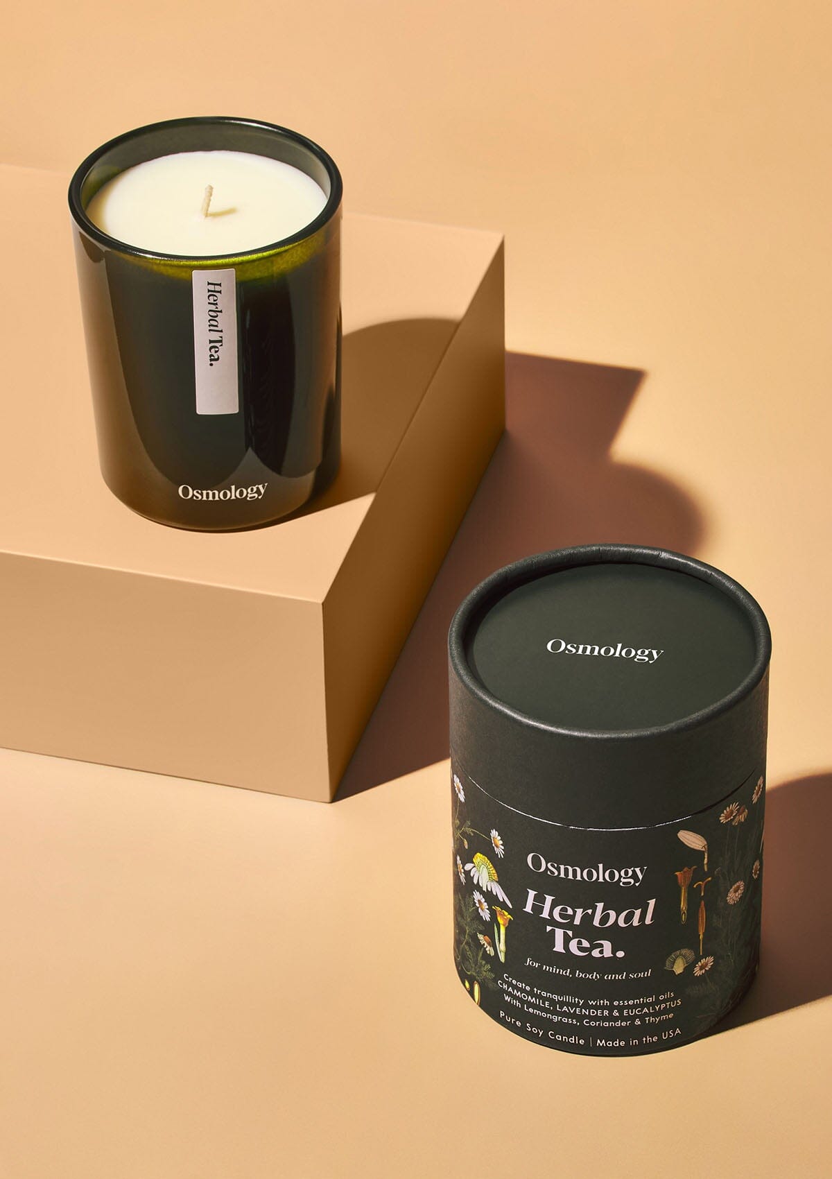 Osmology Herbal Tea candle displayed next to product packaging