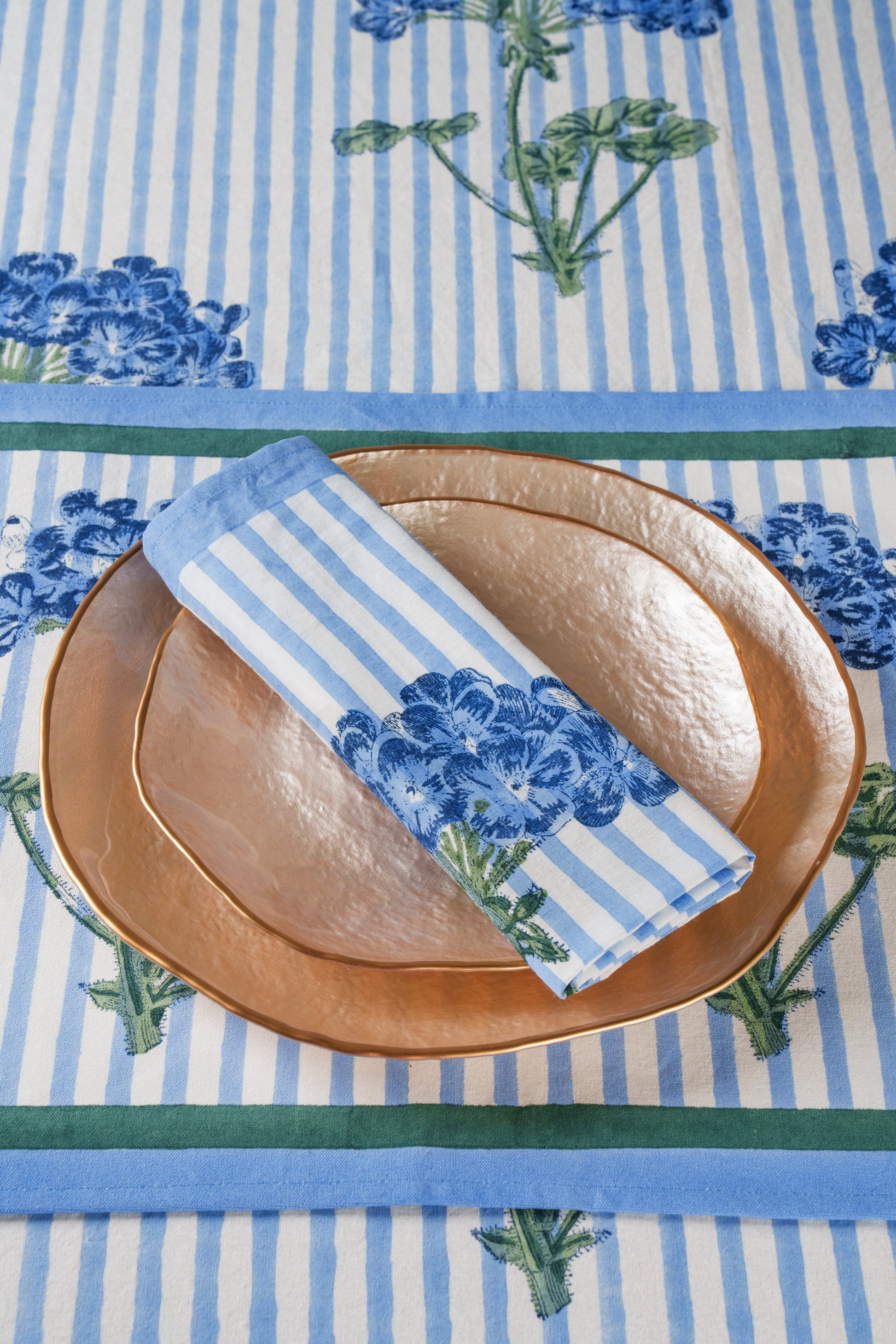 Blue hydrangea blockprint napkins with white/blue stripes on copper plates