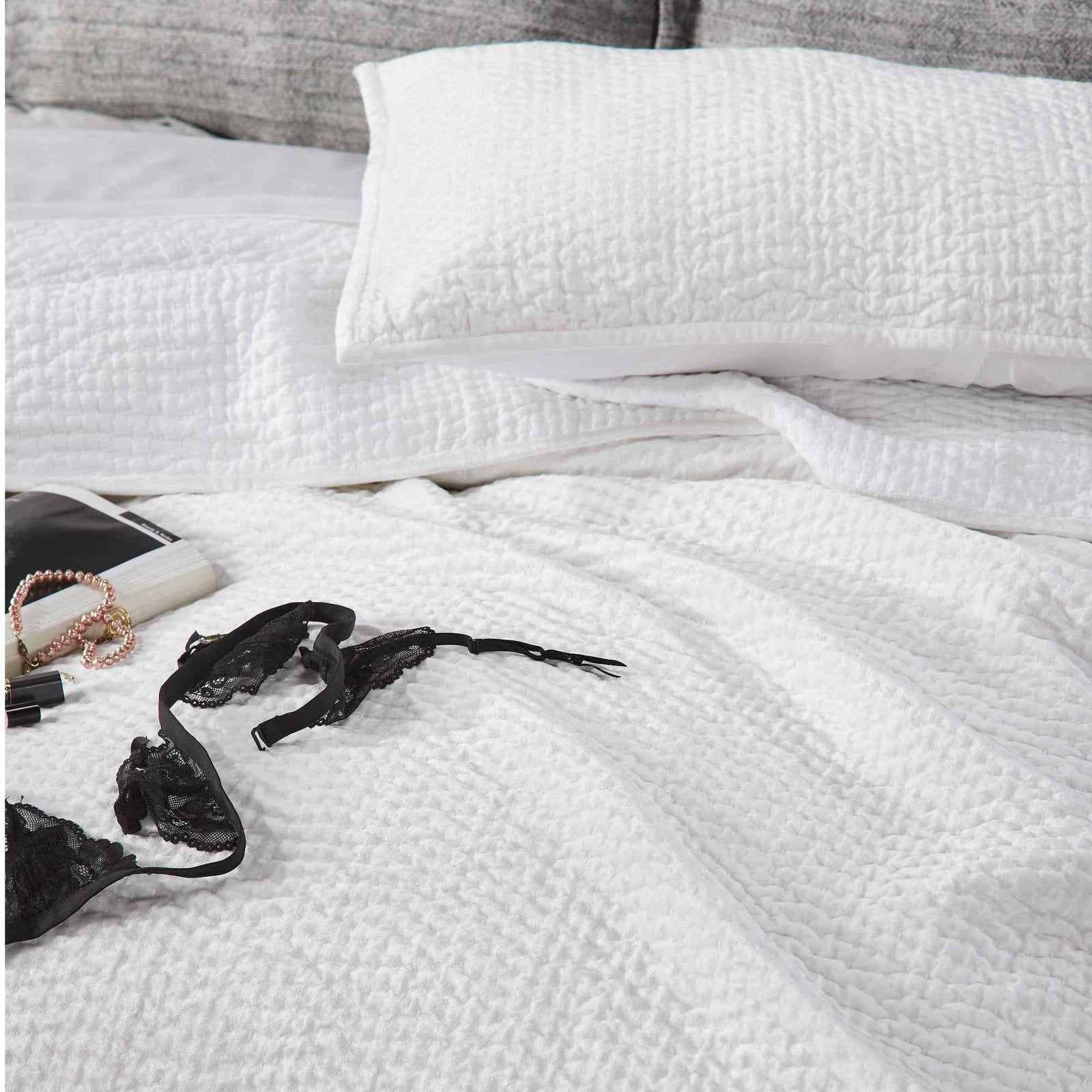 CL-182-9496-LOT1_5|Elegant white textured waffle weave coverlet with lingerie and accessories, creating a stylish bedroom scene.
