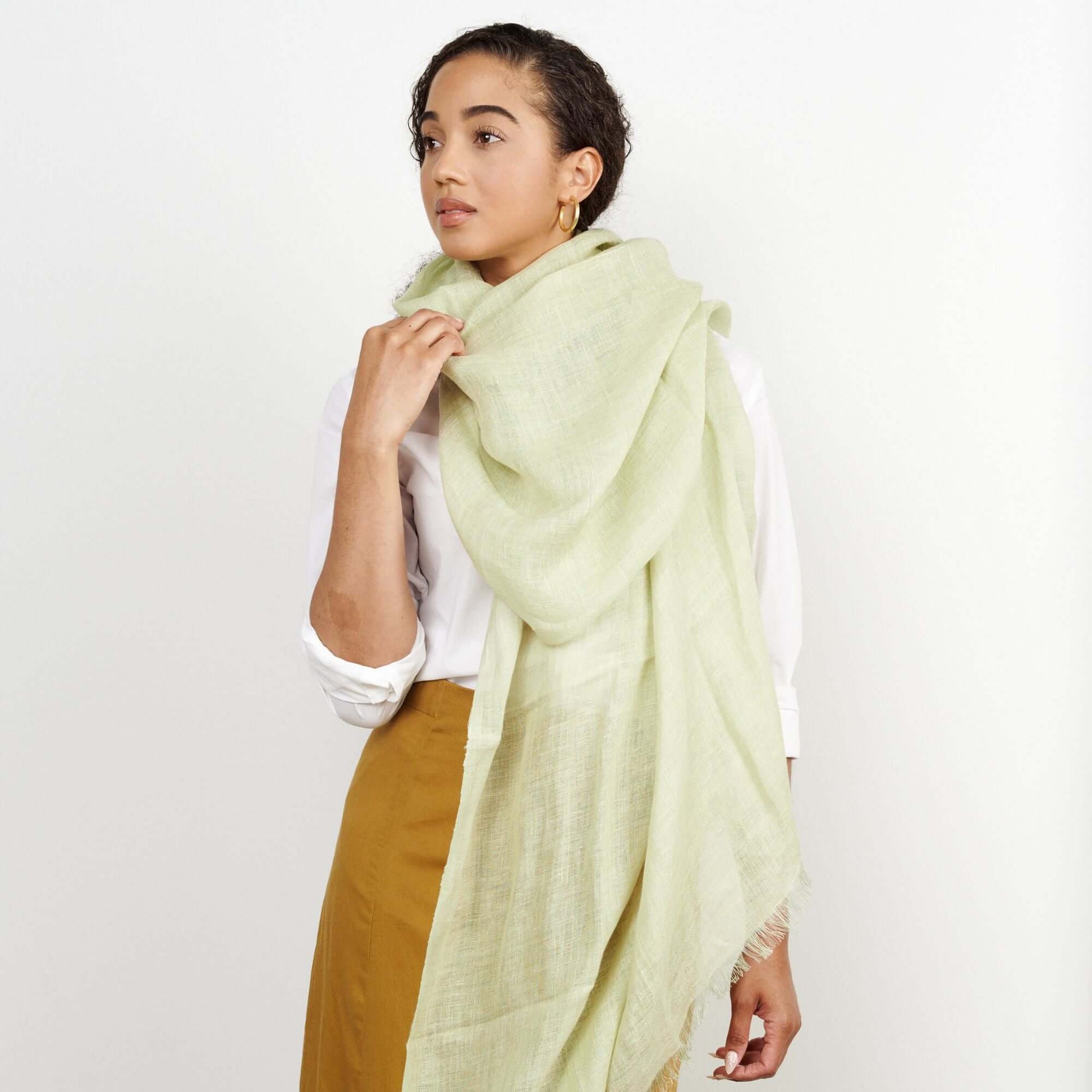 Soya Pastel Lime Green Hand Woven Soft Linen Scarf draped elegantly over a woman's shoulders.