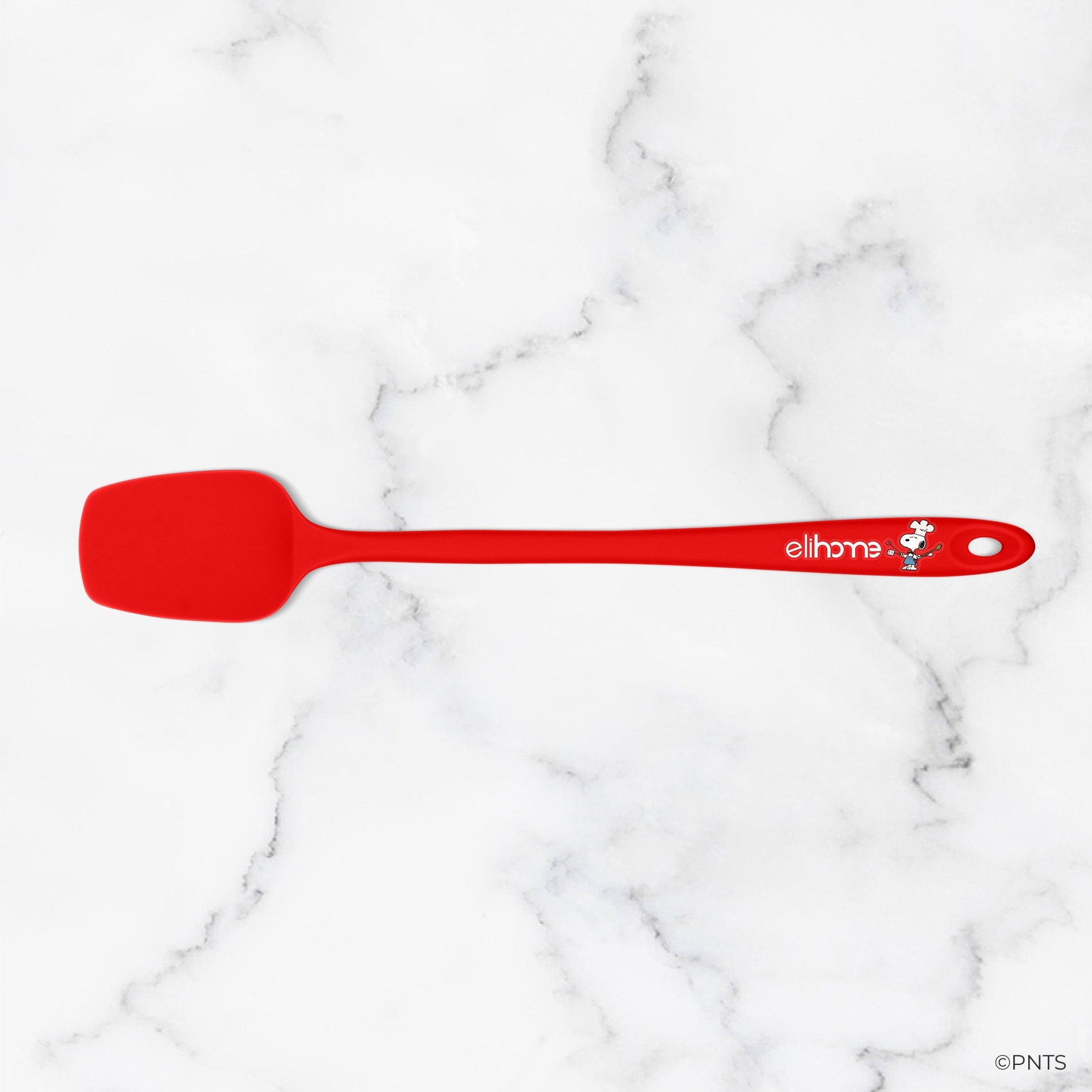 Red spatula with a brand logo on a white marble background