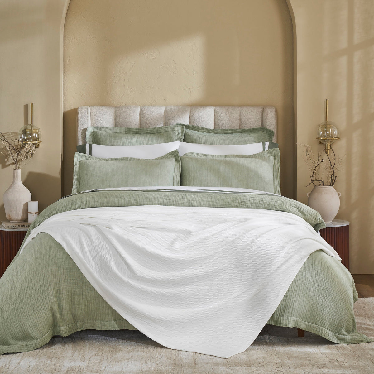 BL-865-11096_1|White textured blanket gracefully draped over the foot of a bed with sage green bedding, enhancing cozy modern style.
