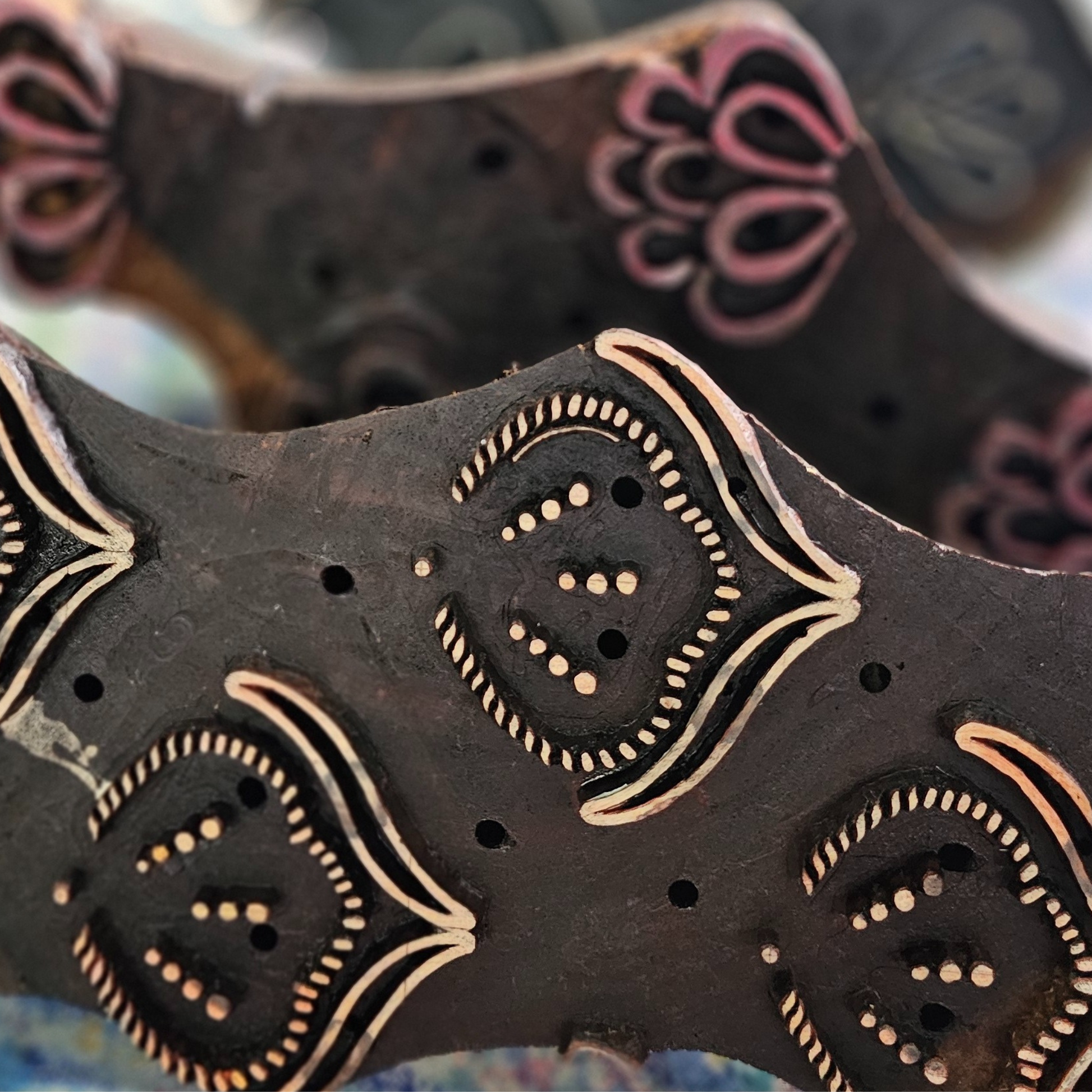 Close-up of peacock feather motif on wooden block. A hand block carving.