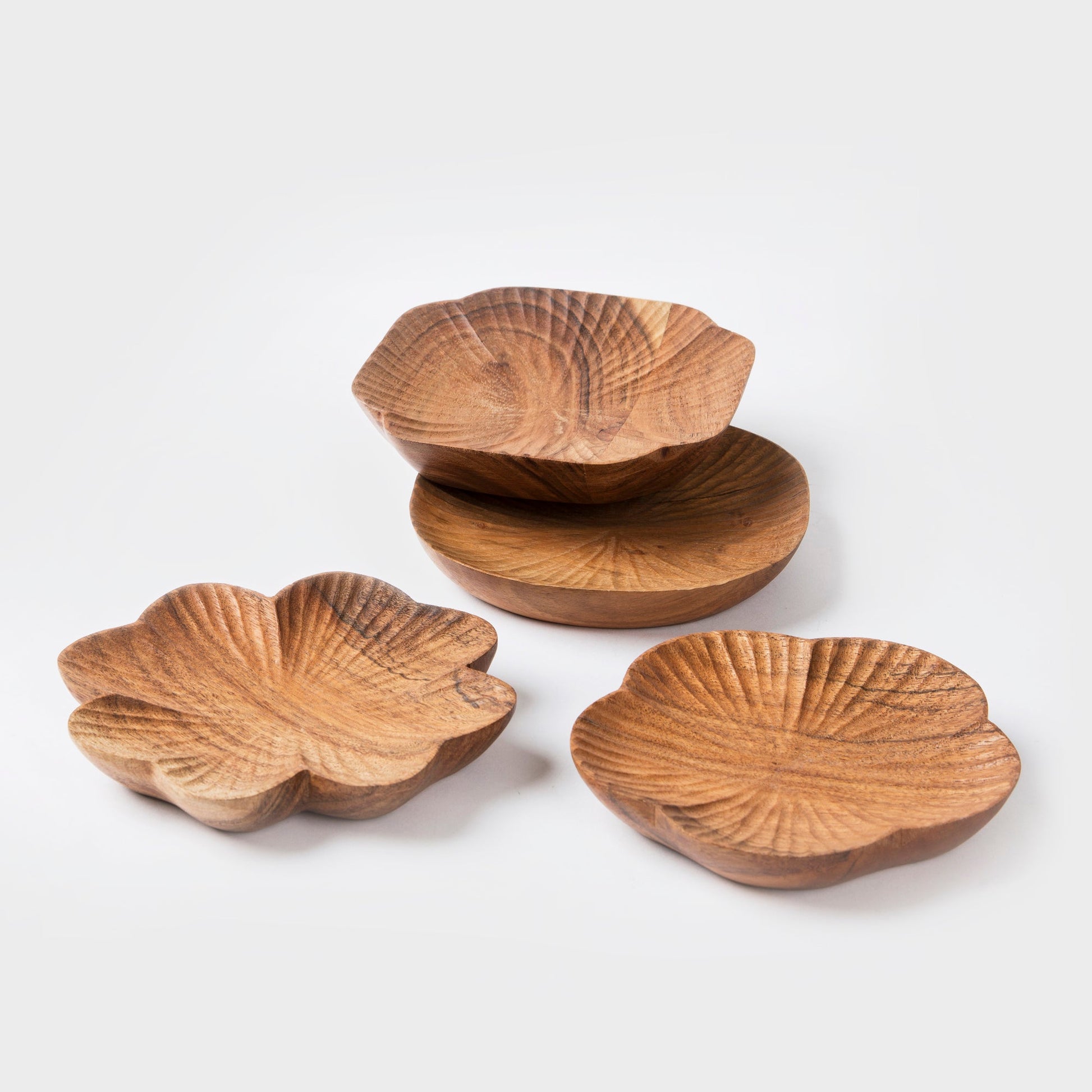 Set of four wooden leaf-shaped bowls on a white background