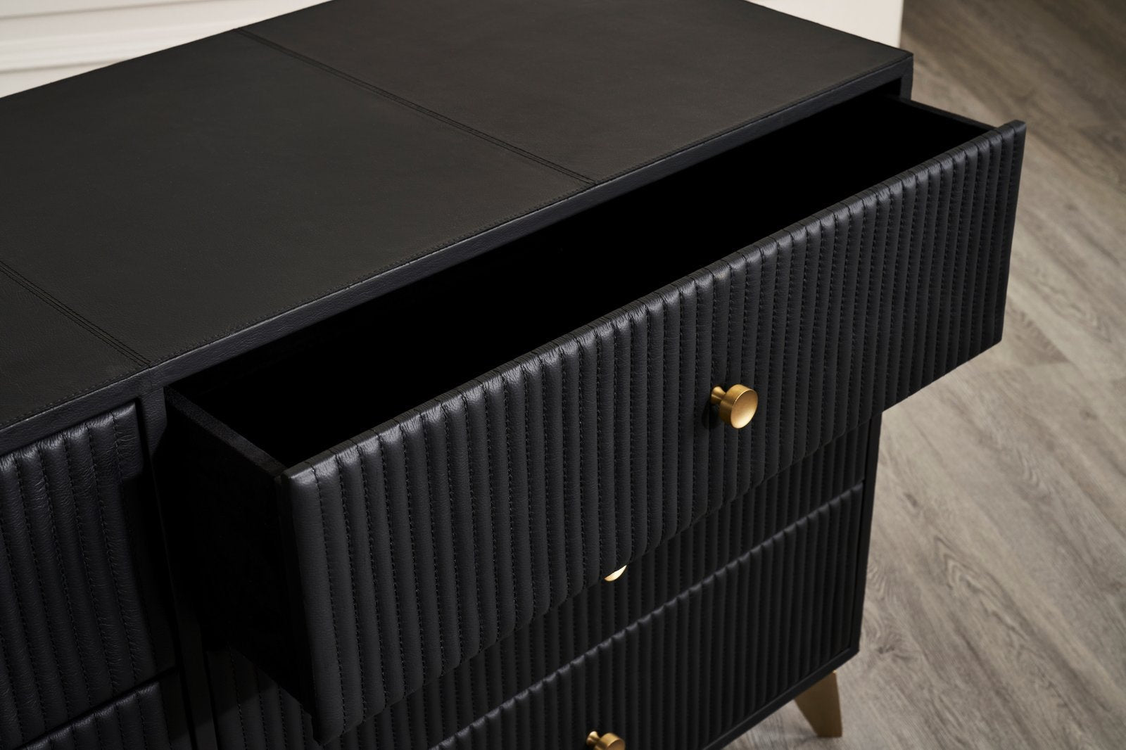 FN-5202-642033_6|Stylish black leather-clad dresser with unique channel-tufted drawers and chic gold hardware, perfect for luxurious bedrooms.