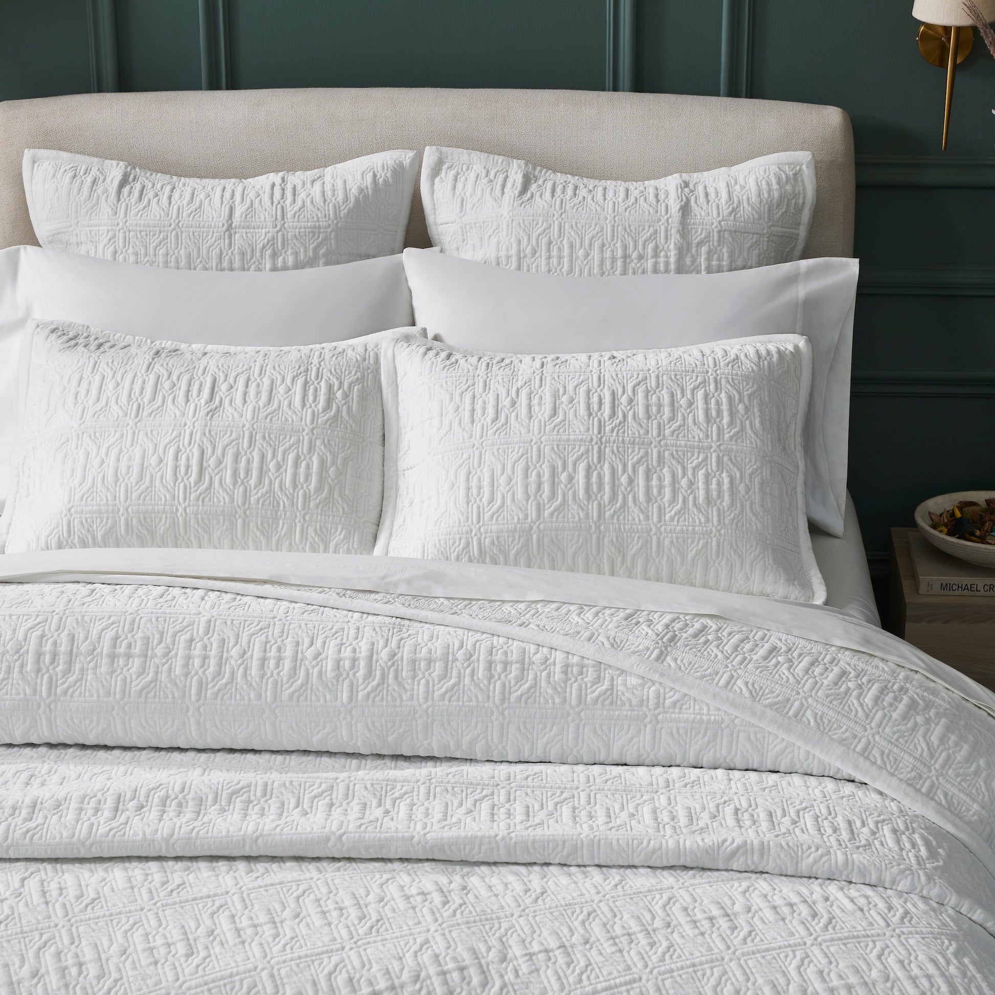 QT-376-9496_3|Close-up of white quilted pillows and quilt, intricate geometric pattern. Adds luxurious texture and sophisticated comfort to bed.