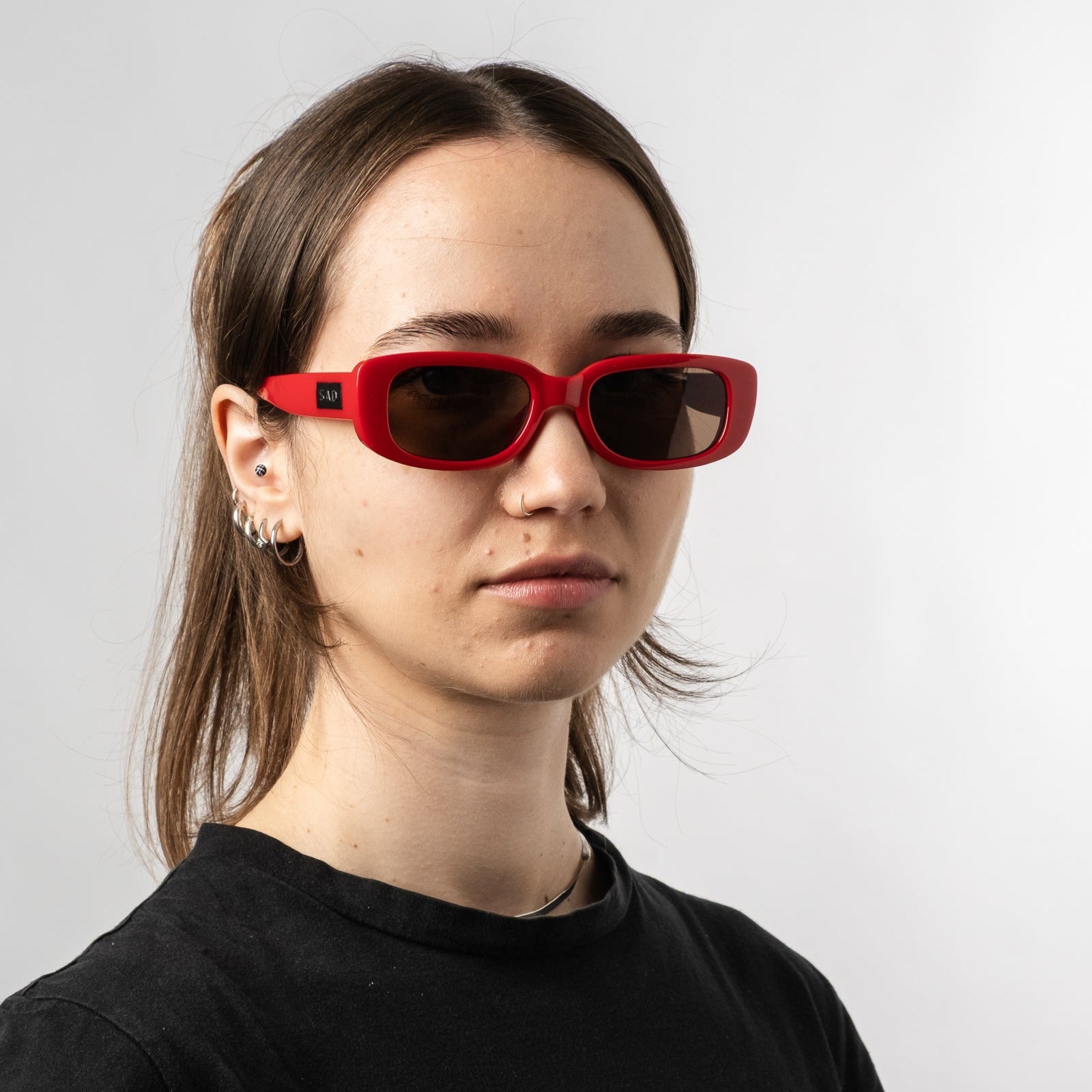 Female wearing Sad Eyewear Bouquet rectangle sunglasses in cherry red with uv protection lenses