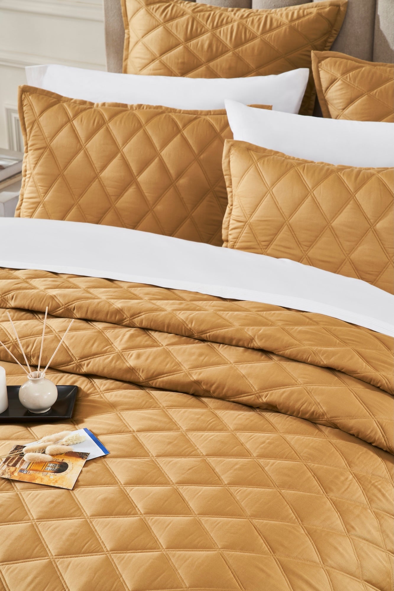 CL-260-11096_4|Close-up of luxurious gold diamond quilted coverlet on a bed, highlighting the elegant pattern and soft fabric.