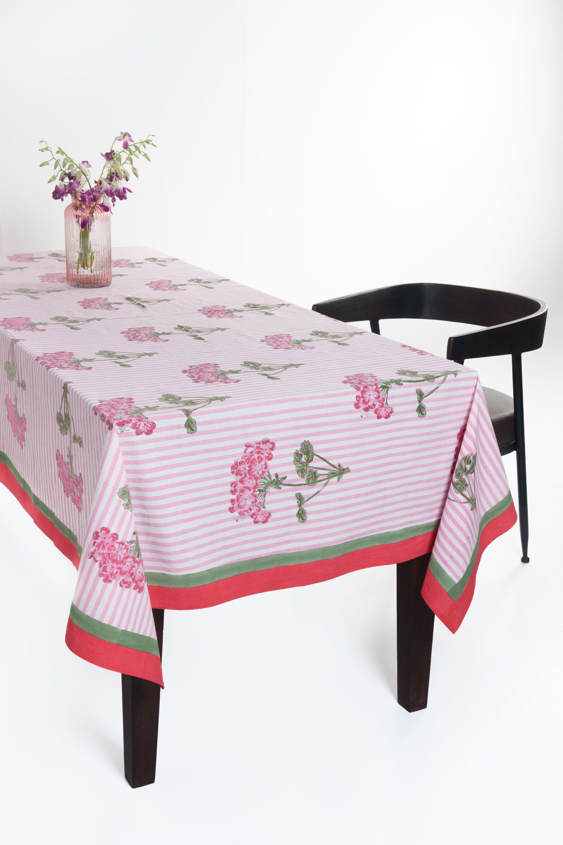 Pink hydrangea blockprint tablecloth draped over wooden table
