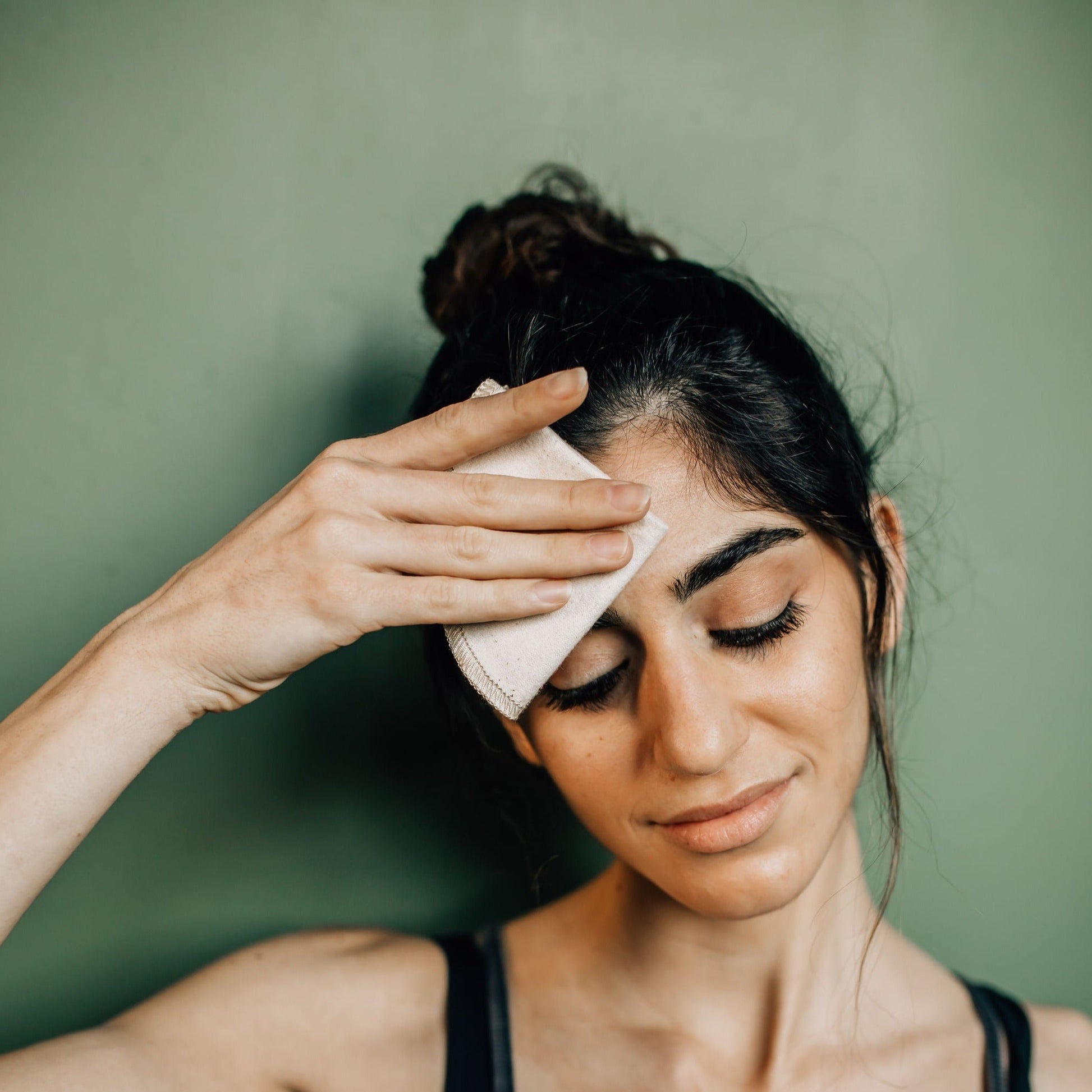 woman using a reusable makeup remover cloth