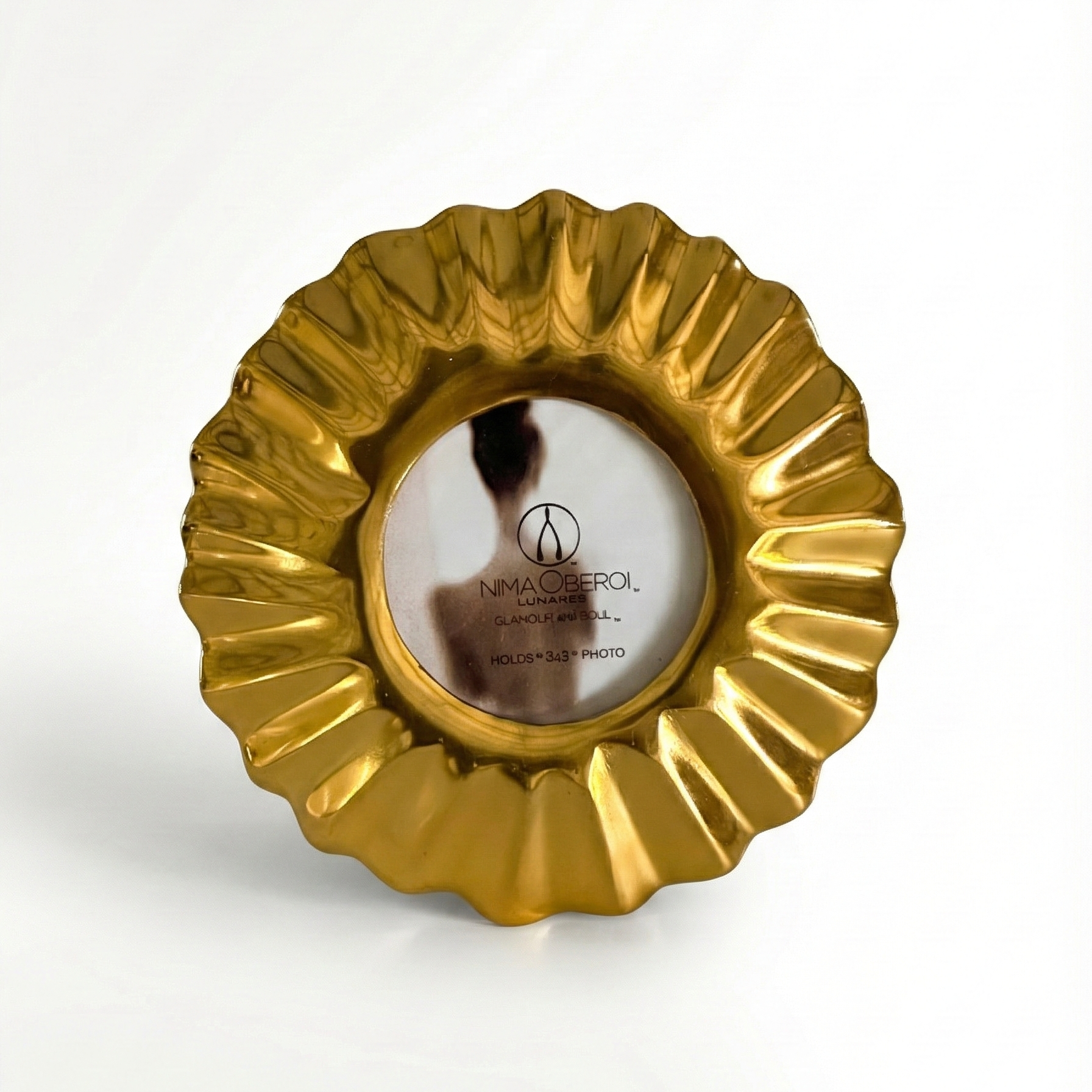 Gold decorative item with a brand logo on a white background