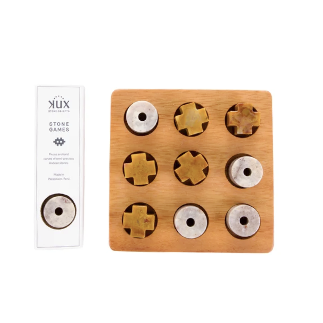An elevated view of the handcrafted gemstone Tic Tac Toe puzzle game, locally known as 'Michi', perfectly arranged to show the unique geometric carving of the natural Andean stone pieces.