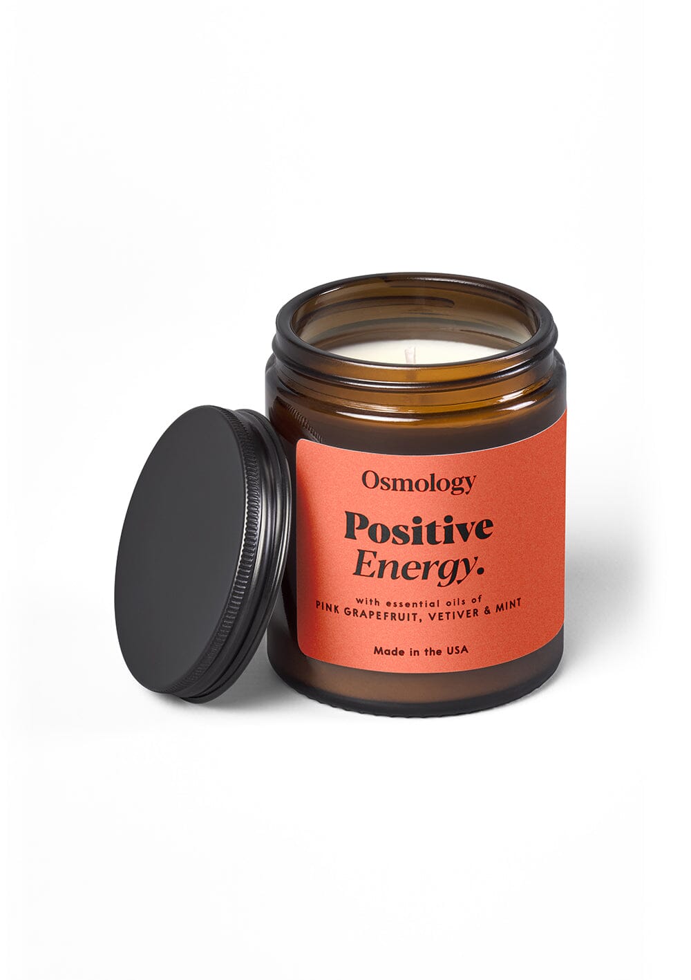 Osmology Positive Energy jar candle with open lid on grey-cream background