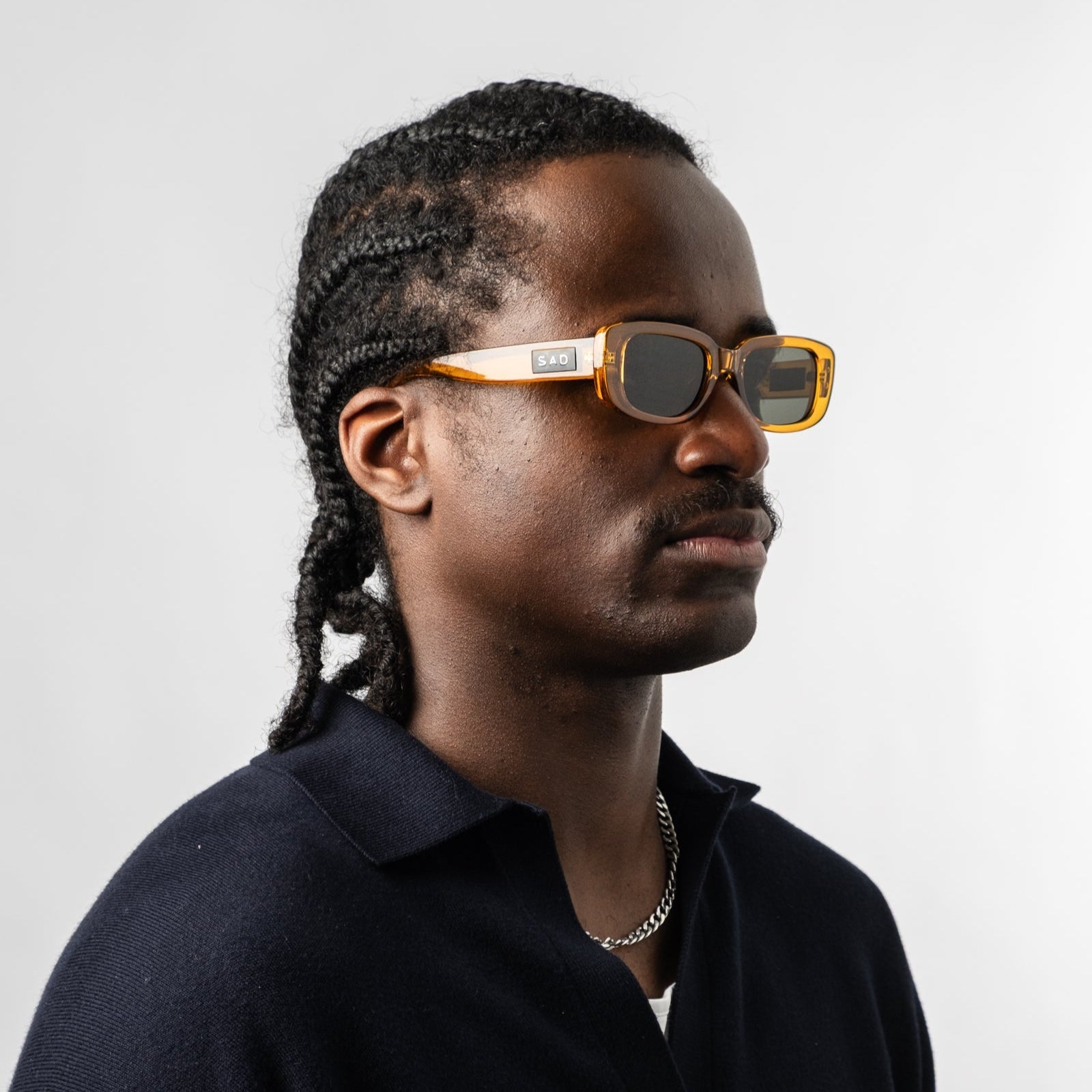Male wearing Sad Eyewear Bouquet rectangle sunglasses in amber with UV protection lenses