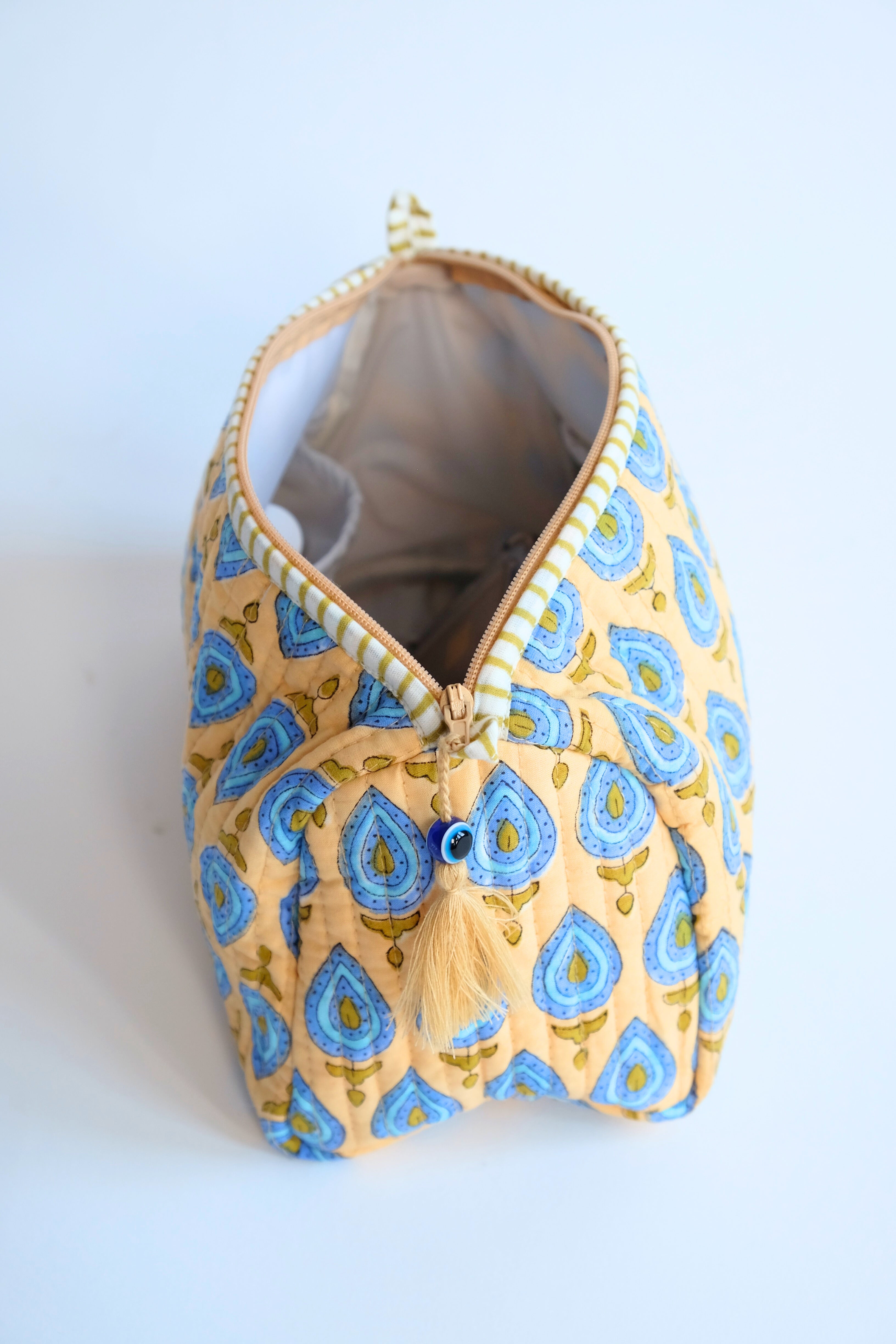 Beige quilted evil eye toiletry bag with zipperand tassel charm - Inner Child