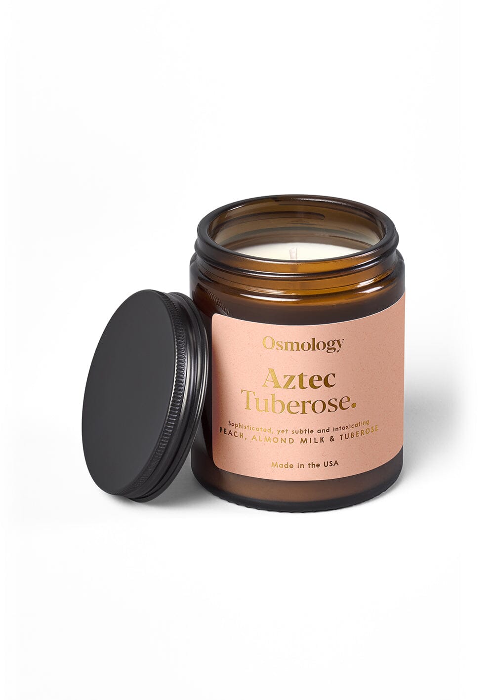 Osmology Aztec Tuberose scented jar candle with lid off, on yellow-cream background