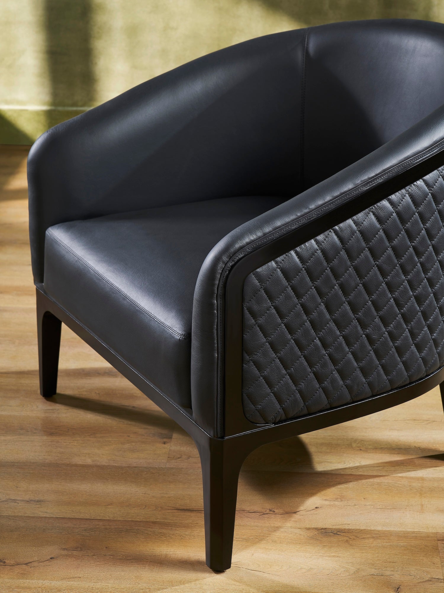FN-5205-343329_6|Close-up of luxurious black leather armchair showcasing intricate quilted side panel and fine craftsmanship, enhancing home decor.