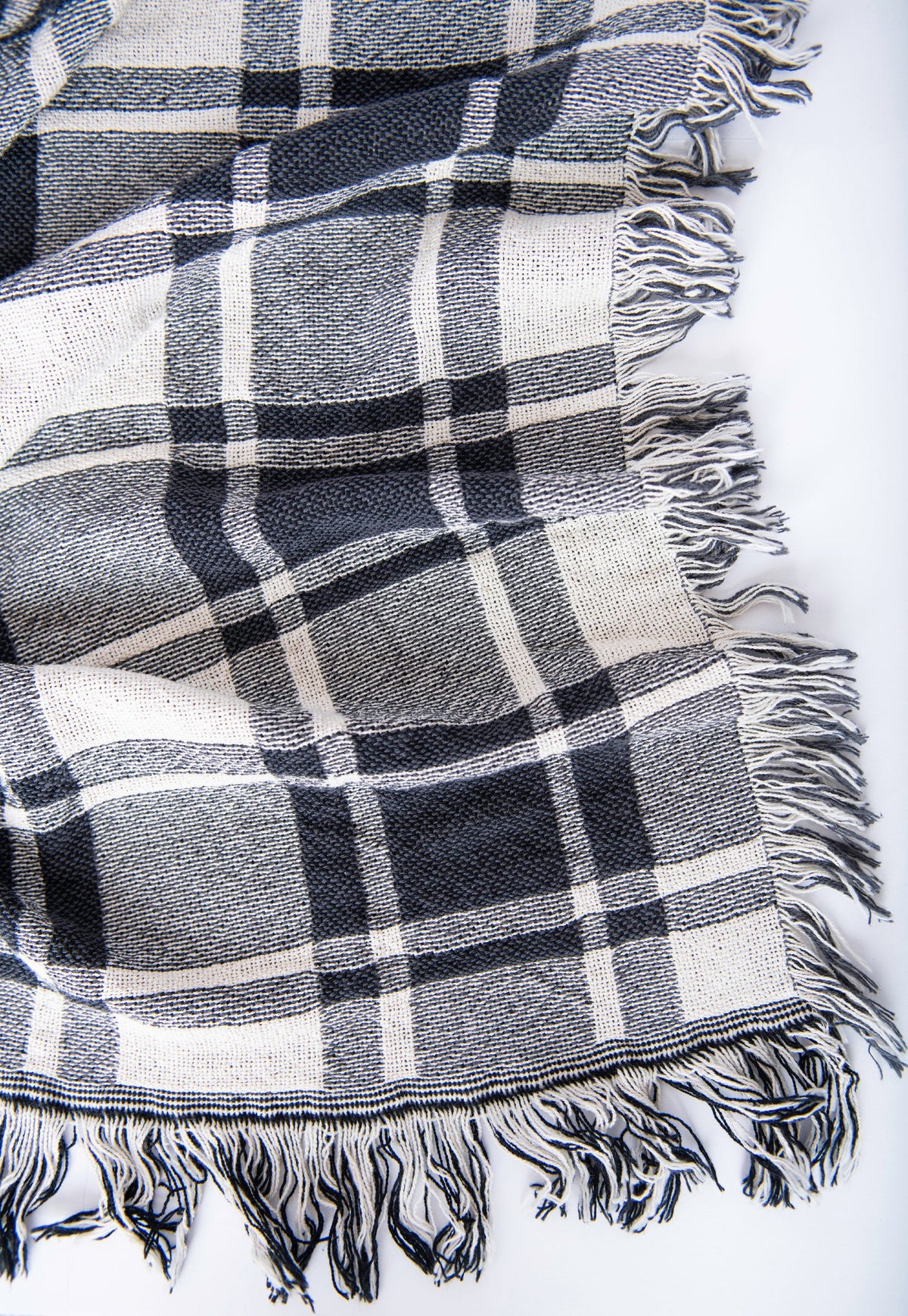 Close-up of Ellis black, gray, and cream plaid woven cotton throw with fringe
